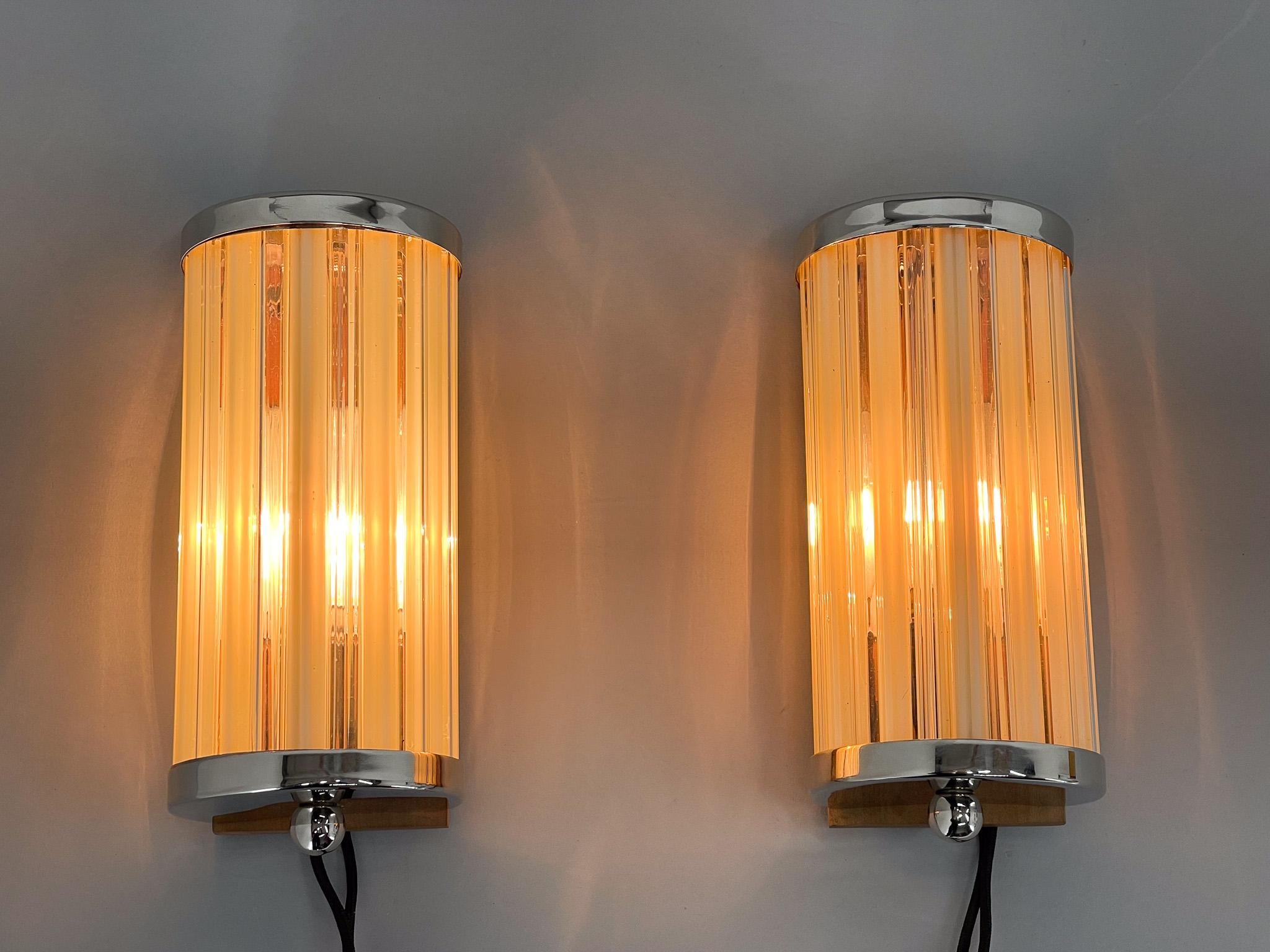 Unique set of two rare wall lights made of glass, chrome and wood. Matching chandelier available. Very good condition (see photo) restored, rewired. 
Bulbs: 2 x E14. 
US wiring compatible.