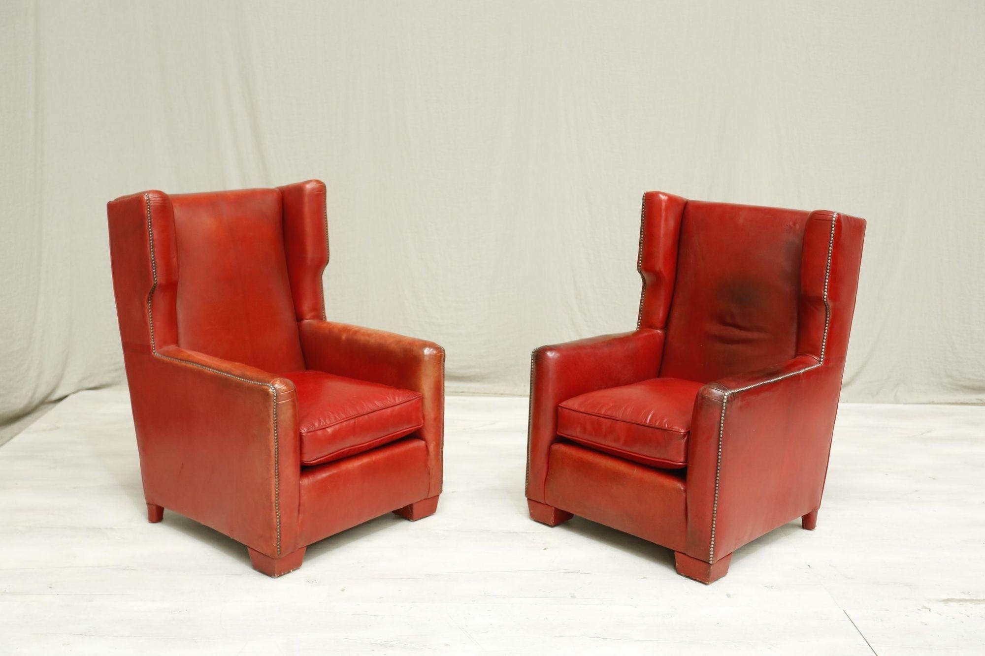These are an exceptional pair of 1940's leather armchairs in the most incredible red colour. The patina is just right and the colour is rich making these hugely decorative items. As well as very comfy everyday chairs. The backs are crushed velvet
