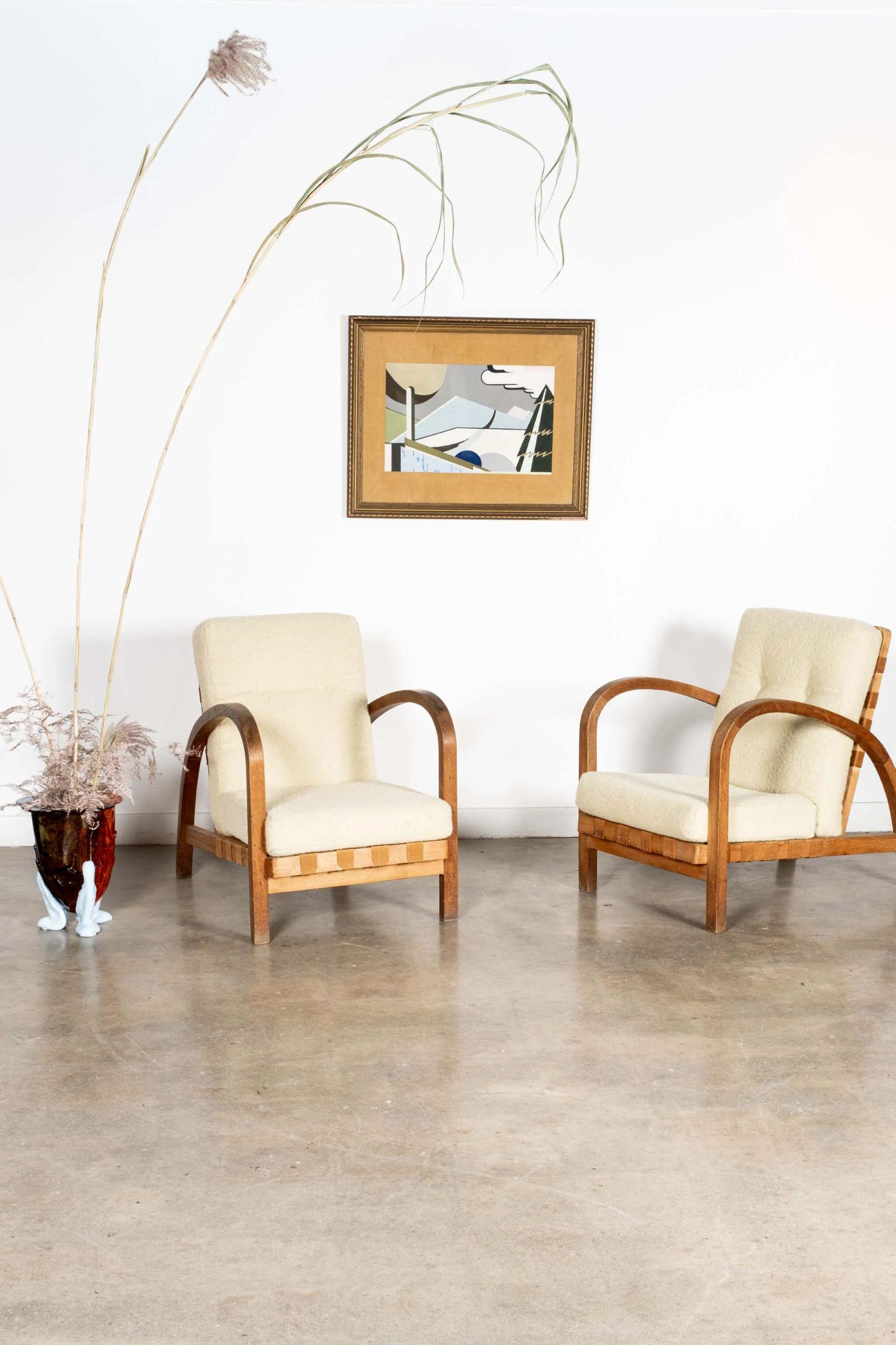 Ein Paar ausgezeichnete Stühle. Die belgischen Holzrahmen aus den 1940er Jahren sind mit geschwungenen, runden Armen und originalen Baumwollgurten ausgestattet. Aktualisiert und akzentuiert mit neuen Kissen aus einem vanillefarbenen Bouclé-Stoff. 
