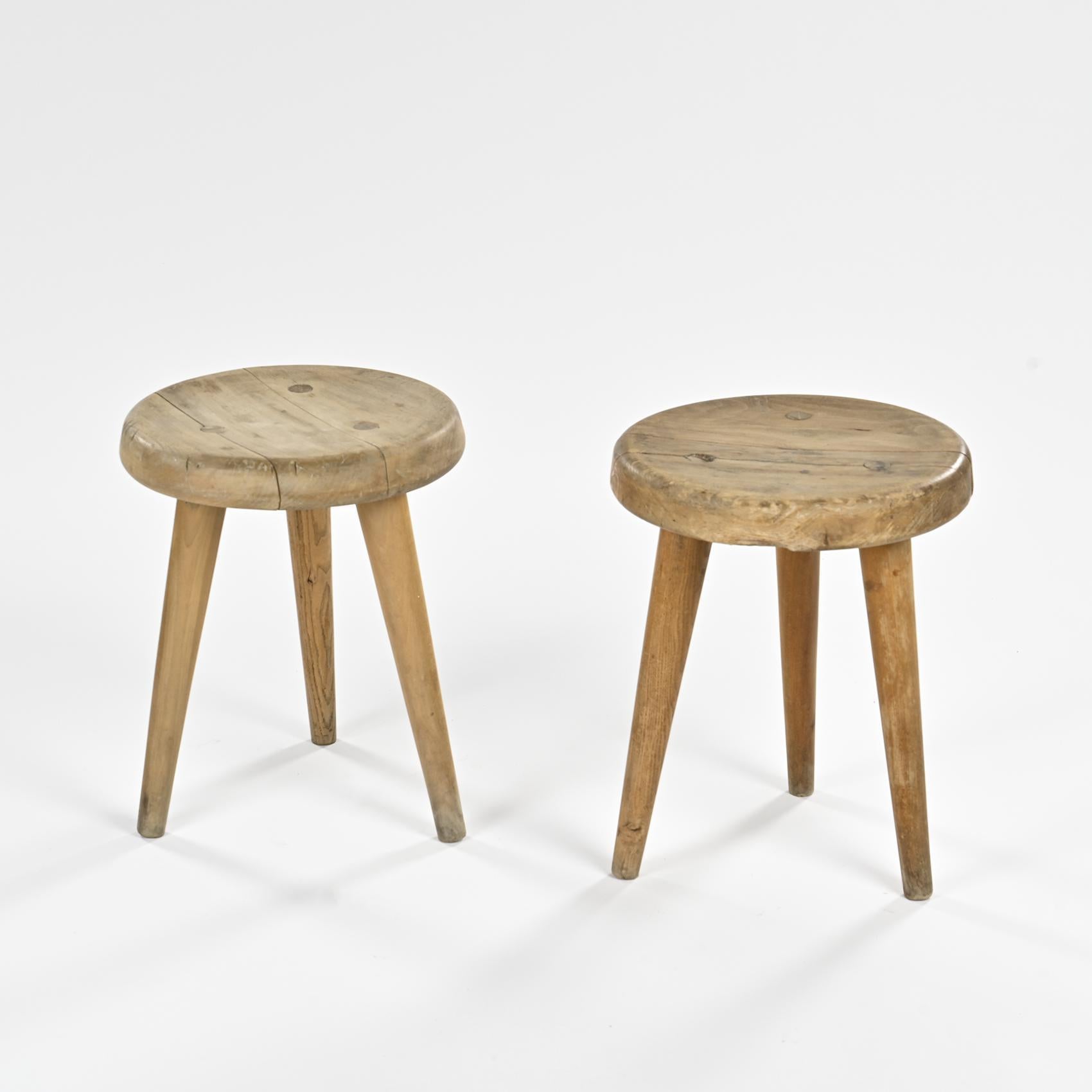 Presenting a pair of captivating and mysterious French tripod stools. 

This pair represents an extremely rare and perhaps unique discovery. 

Sourced from a sophisticated home in the french countryside with Charlotte Perriand and Pierre Jeanneret