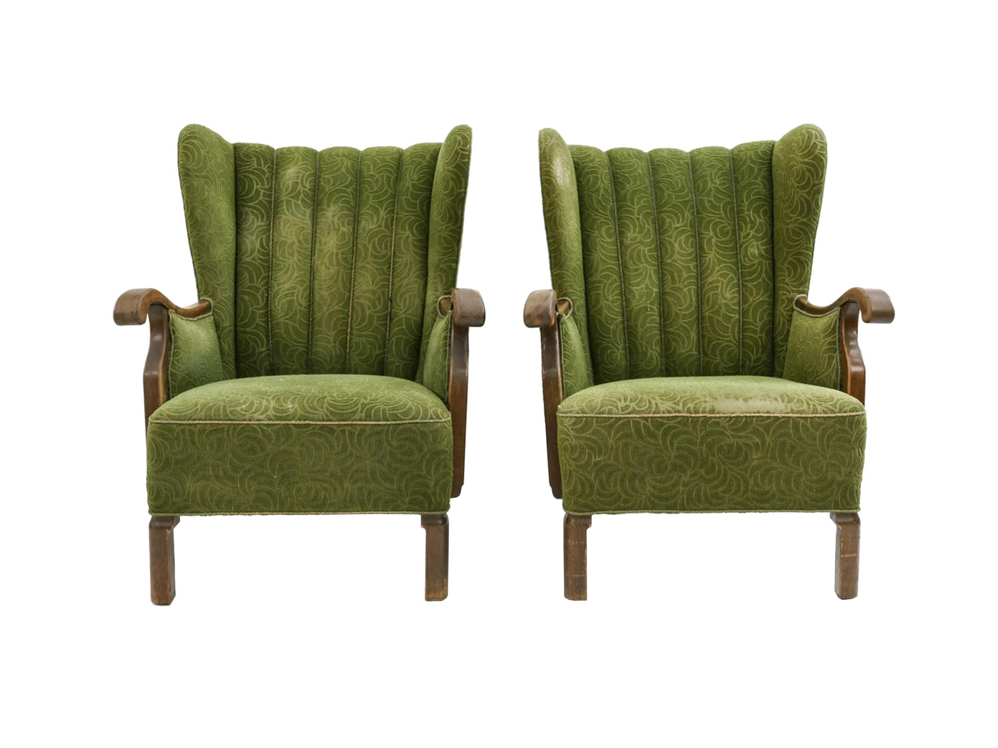 These Danish armchairs were designed by Viggo Boesen and made by Slagelse Møbelværk in the 1940s. Original green, embossed pattern fabric. The chairs are designed with an elegant scallop back, curved wood arms, and splayed back