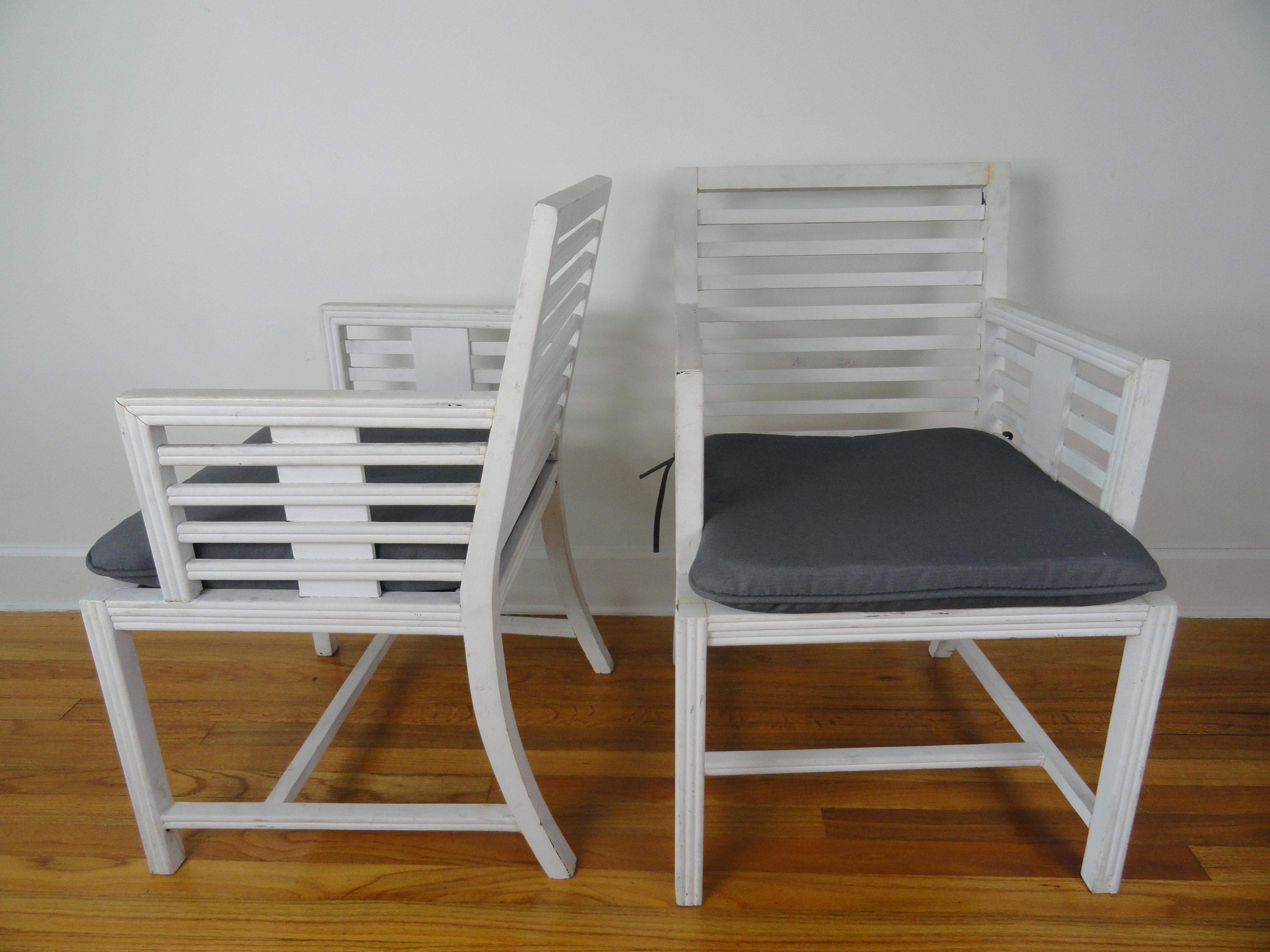 Pair of wood slat armchairs from the 1940s. Painted white. New gray cushions. Bottom stretcher.