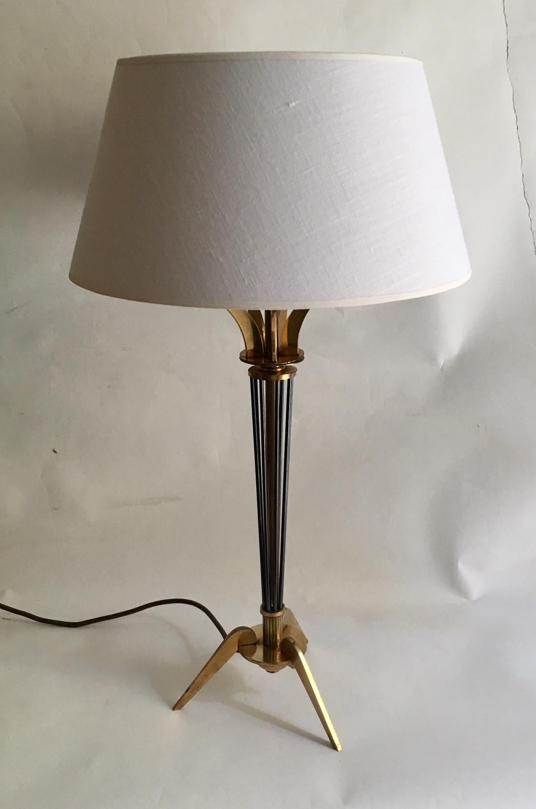 Pair of table lamps by Maison Arlus, gilded brass with conical barrel animated rods with gun barrel patina surmounted by flared blades and terminated by a tripod base. Shades in black and gold interior
From the hotel Claridge near the