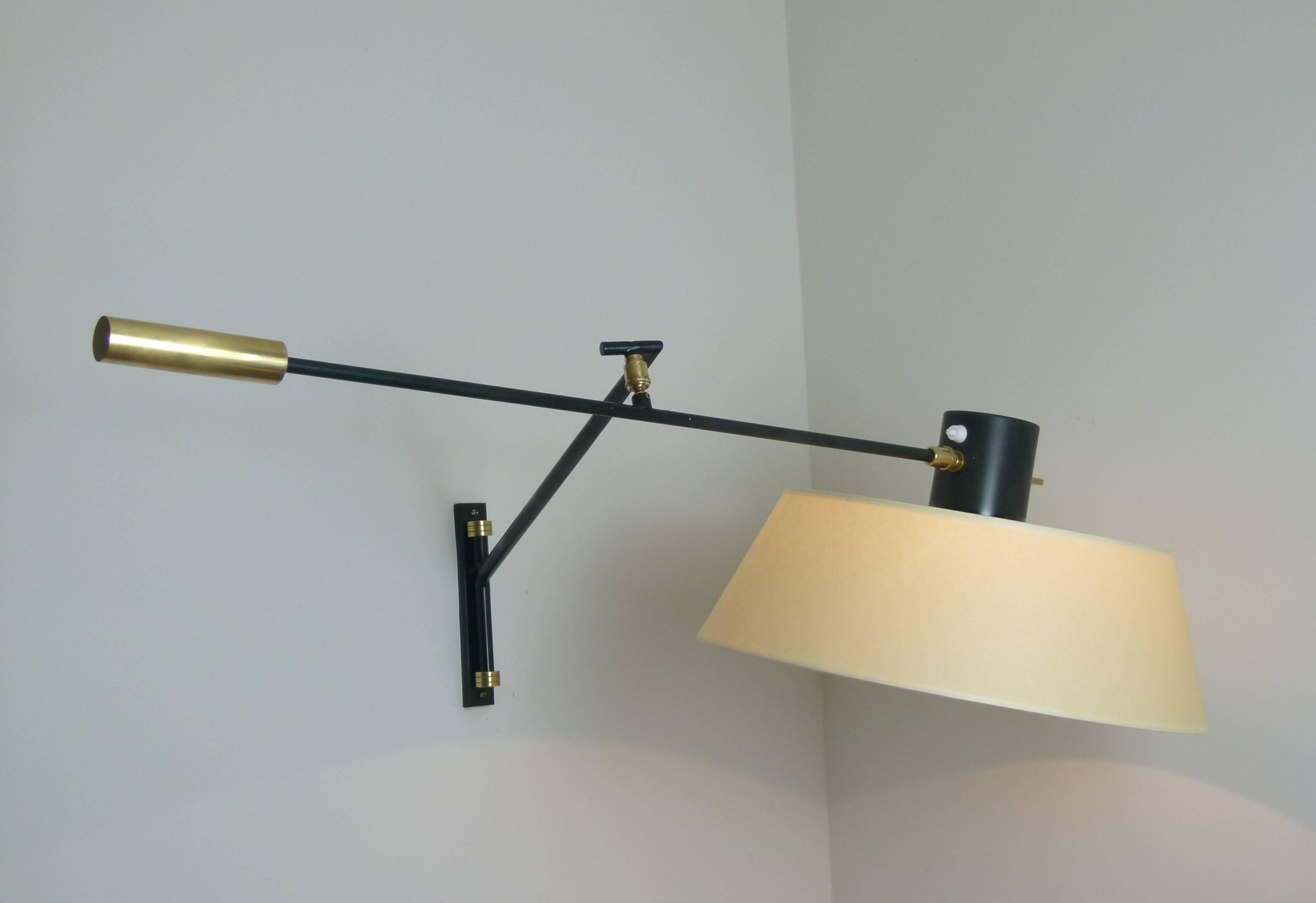 Black lacquered metal and brass sconce consisting of a rectangular base on which is set a swiveling rod linked to black lacquered metal arm linked to another arm by a brass ball that allows orientation.
A solid brass handle is set at the end of the