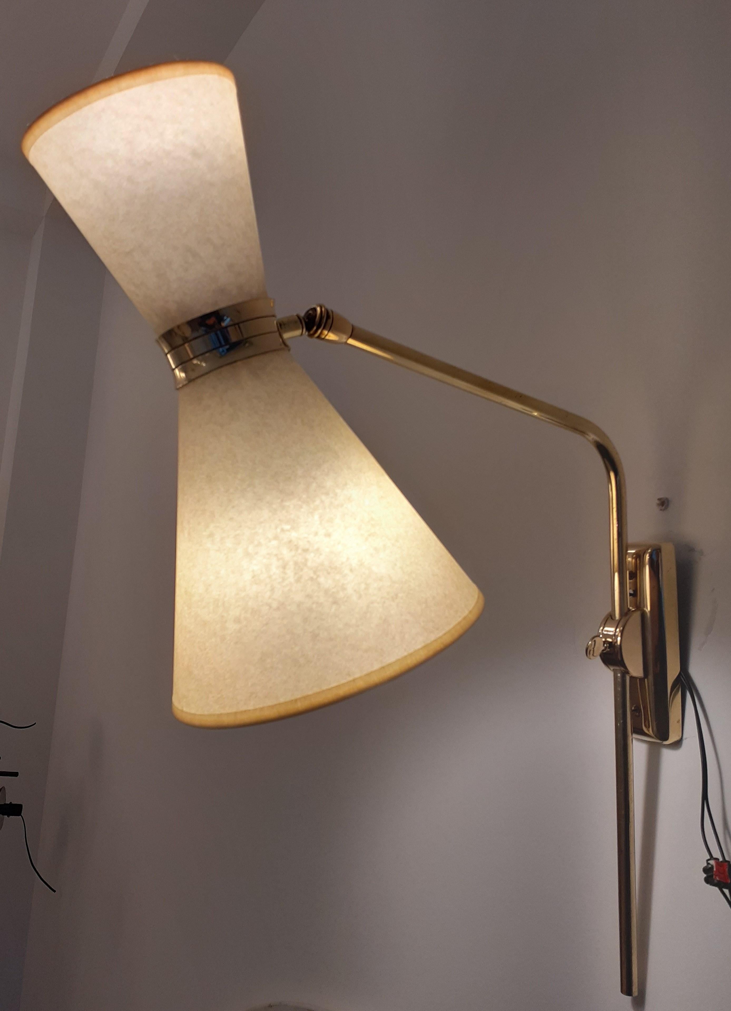 Pair of double-light brass wall lights, composed of a rectangular brass base, on which is fixed a brass arm that can be swiveled from left to right.
terminated by a cylindrical brass support adjustable by a ball joint.
On each support are fixed