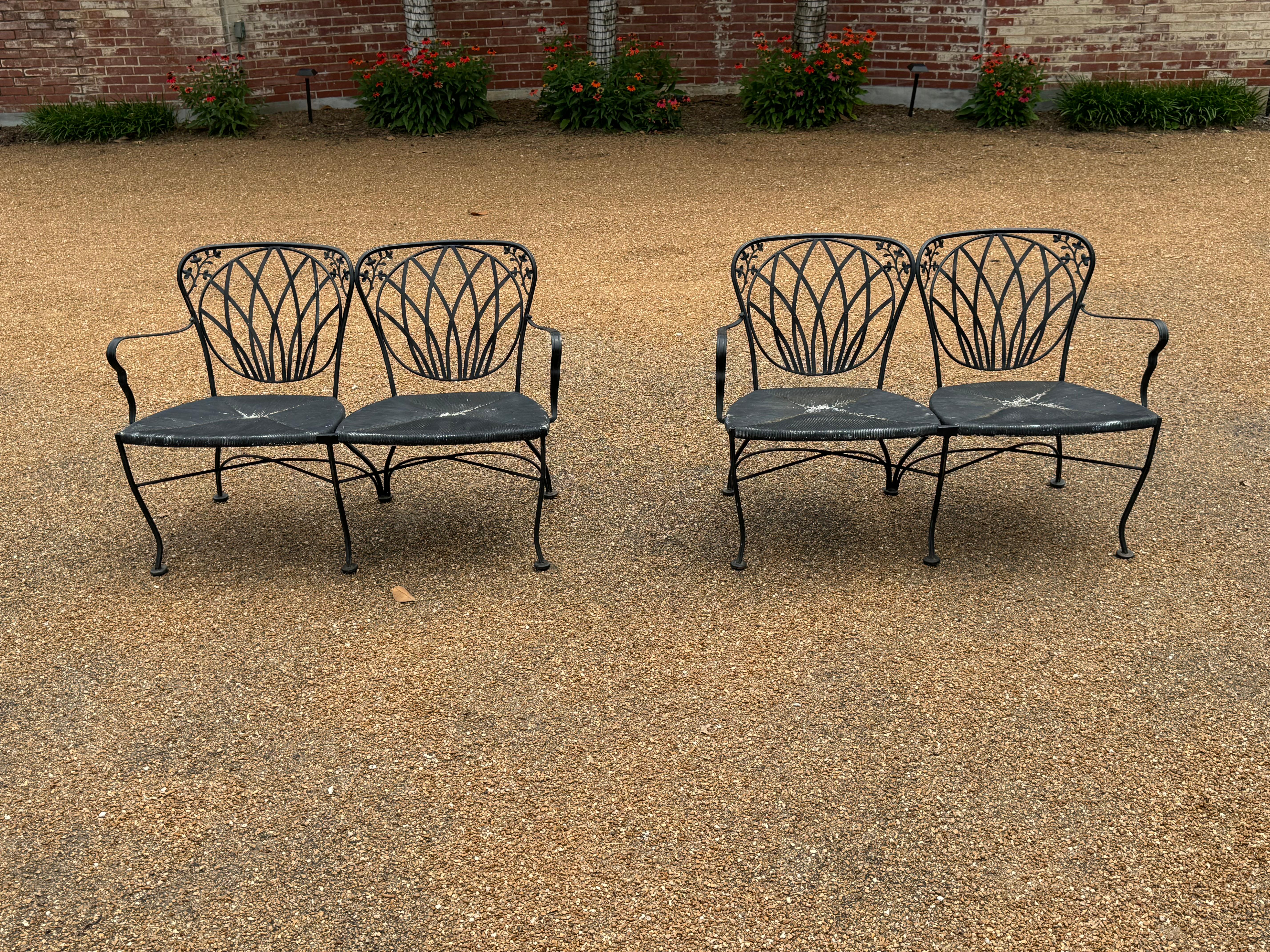 Coppia di divani da giardino o patio in ferro battuto verniciato nero degli anni '50 con rivestimento in plastica finta danese. Vernice originale, presenta alcune perdite. I sedili hanno perso la vernice, ma possono essere facilmente riverniciati. 