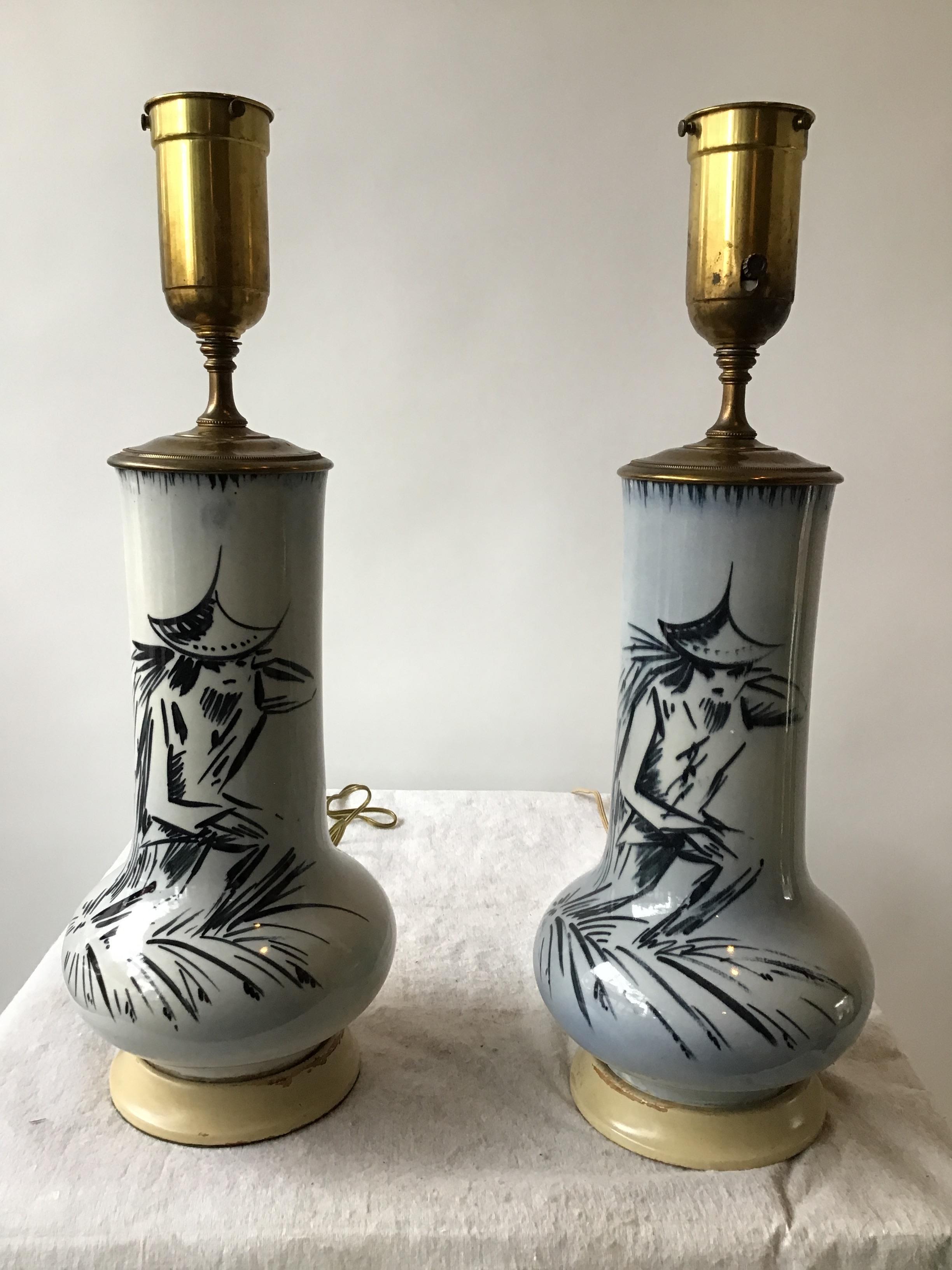 Pair of 1950s blue ceramic Asian figural lamps on wood base.