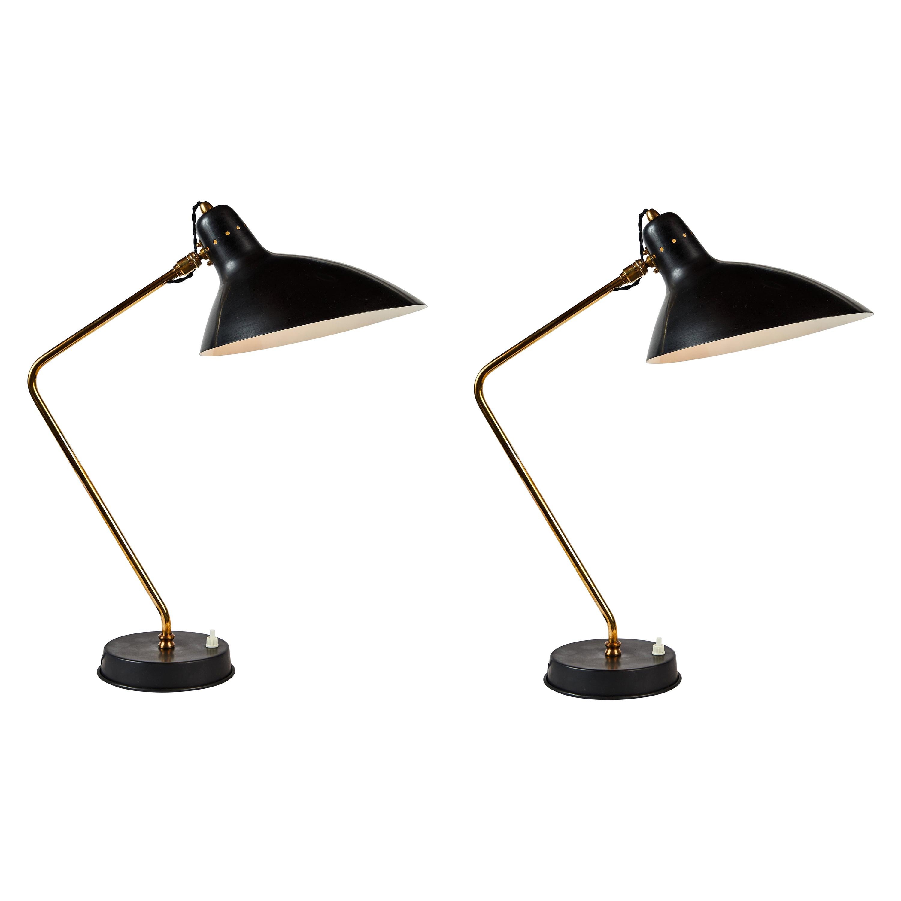 Pair of 1950s Boris Lacroix table lamps. This rare and elegant table lamp is executed in black metal and brass, France, circa 1950s. Shade rotates freely on brass ball joint for high adjustability. A celebrated Art Deco lighting designer who