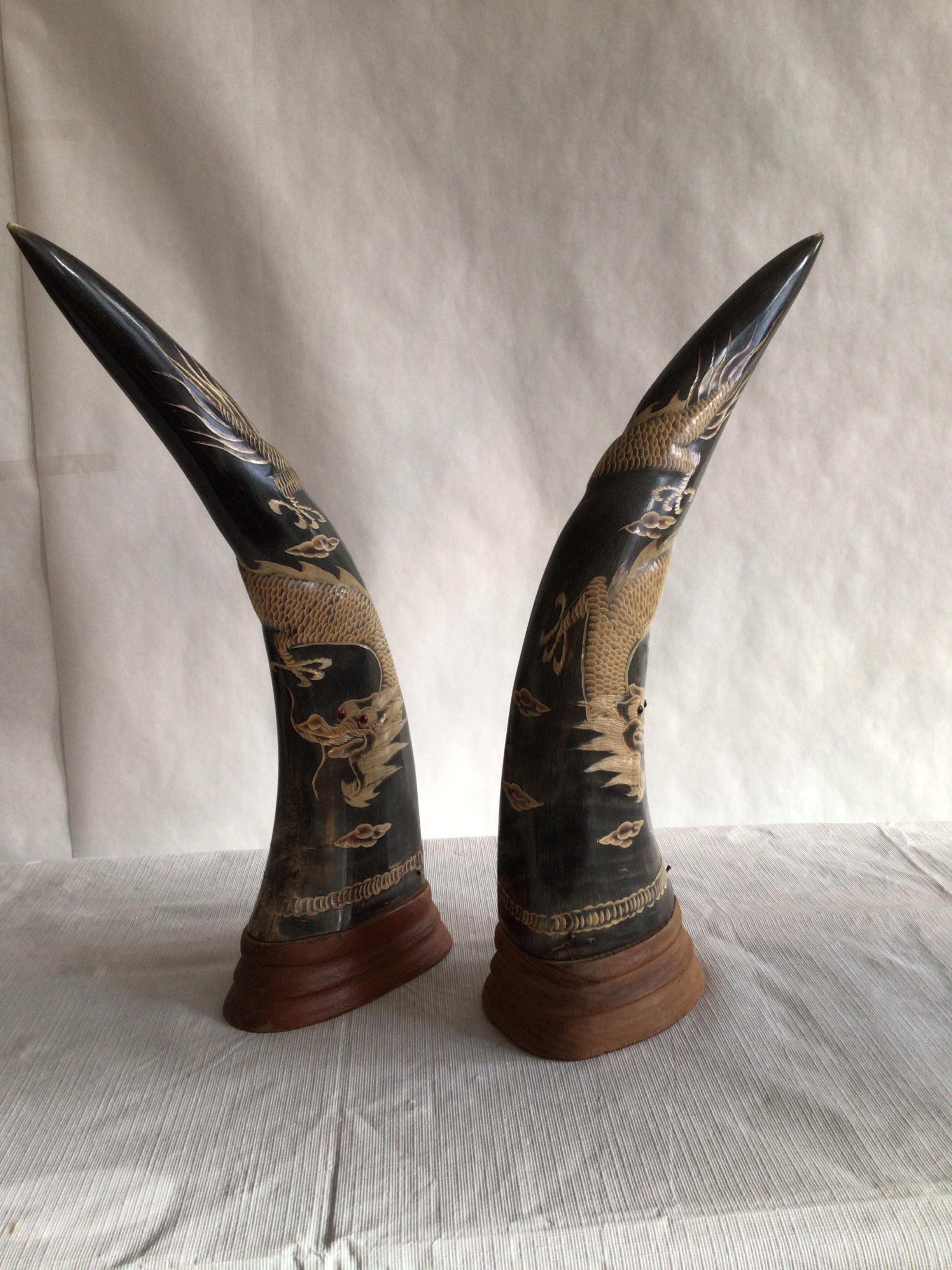 Pair of 1950s carved horns with dragon motif on wood base. 
They are a definite statement piece.