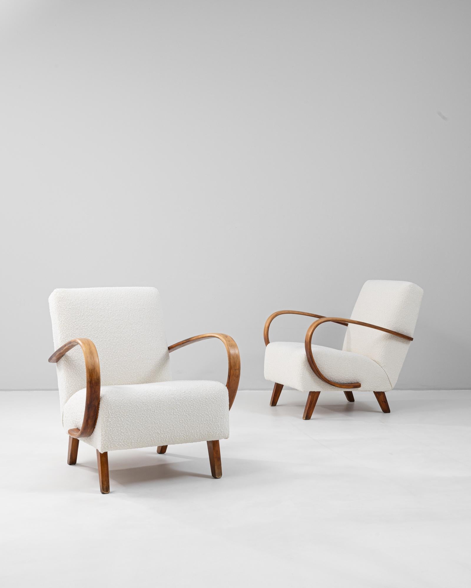 Esta pareja de sillones checos de madera de la década de 1950, obra de J. Halabala, ejemplifica el diseño moderno de mediados de siglo con su característica mezcla de sencillez y elegancia. Todos los sillones tienen los emblemáticos brazos de madera