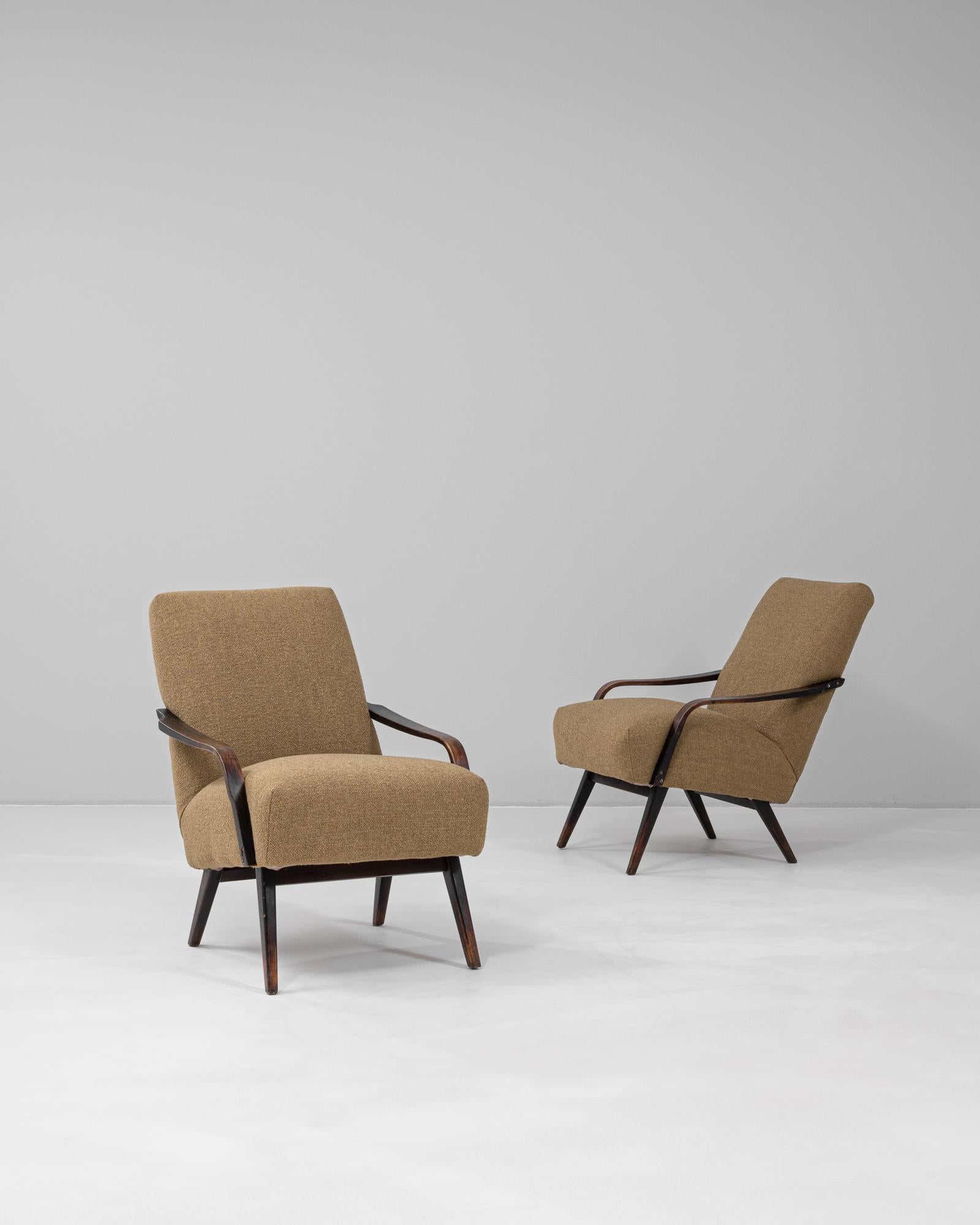 Paire de fauteuils rembourrés tchèques des années 1950 par TON, reflétant l'artisanat raffiné et le modernisme organique caractéristiques du design d'Europe centrale d'après-guerre. Ces chaises sont dotées d'accoudoirs élégamment courbés en bois