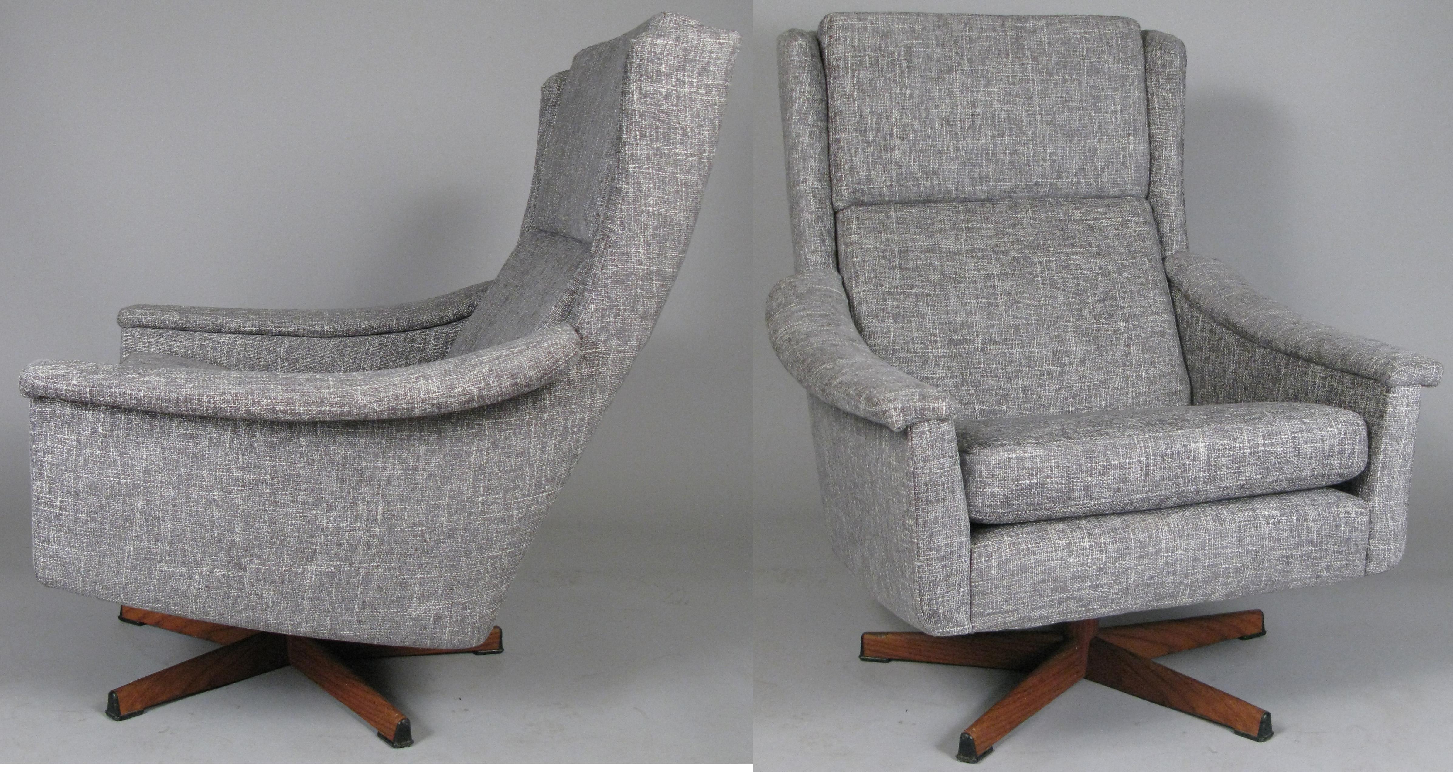 A beautiful pair of vintage 1950s high back lounge chairs, purchased from Illums Bollighus, with swivel bases of steel with wood veneer overlay. Incredibly comfortable, with curved arms and high cushioned backs. These have just been reupholstered in