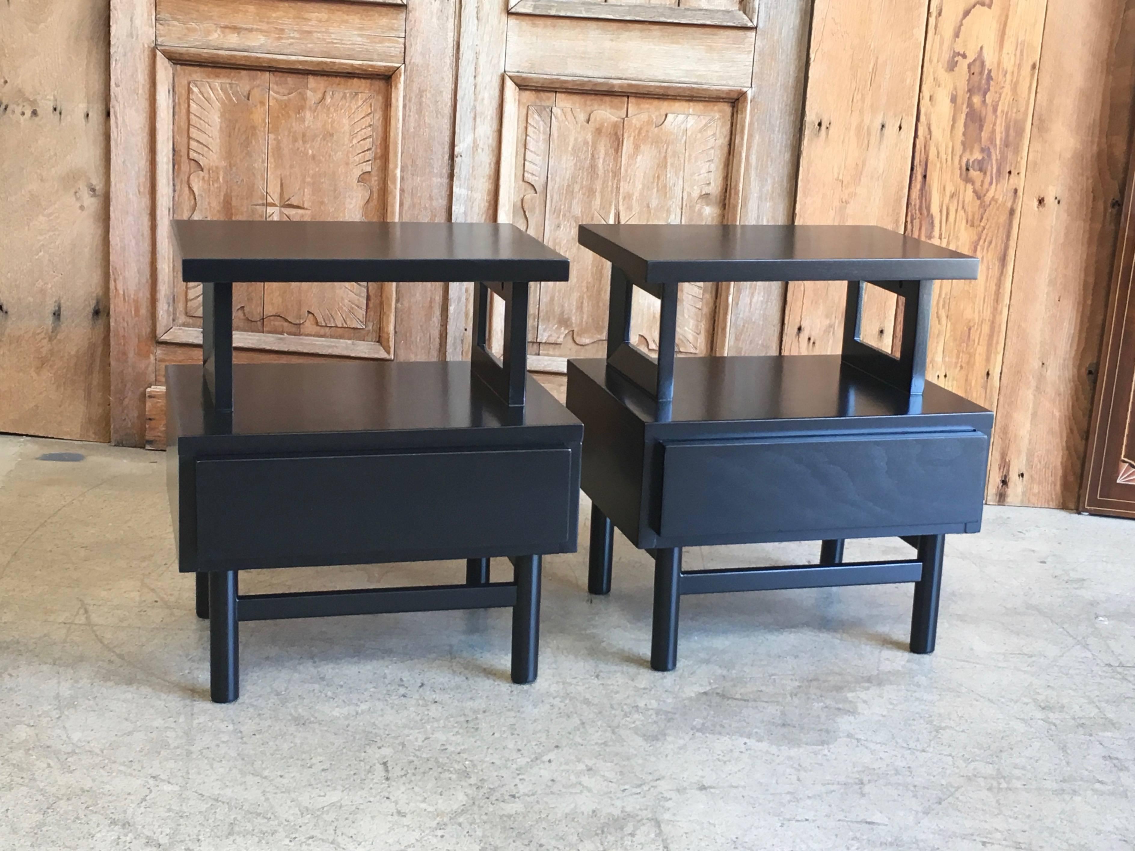 Two-tiered nightstands with a single drawer in a ebony stain with a satin finish.