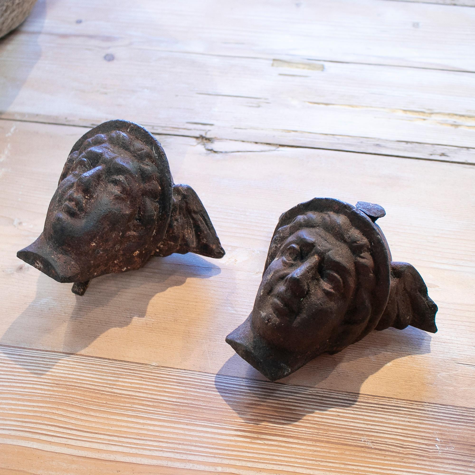Pair of 1950s French cast iron winged head busts of Mercury, the Greek god of financial gain and commerce.