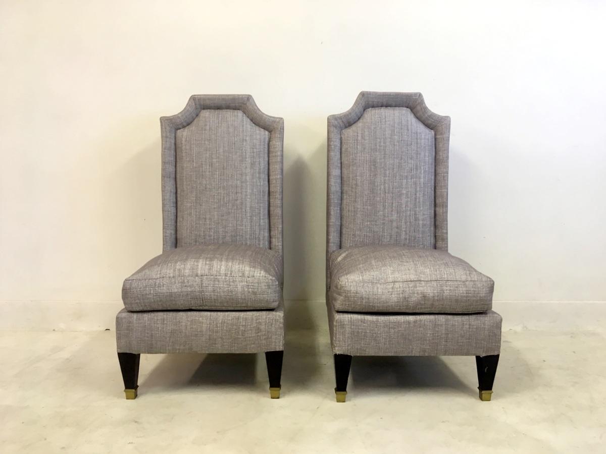 A pair of high back chairs

In the style of Jean Pascaud

Grey linen 

Black legs 

Brass feet

1950s-1960s.