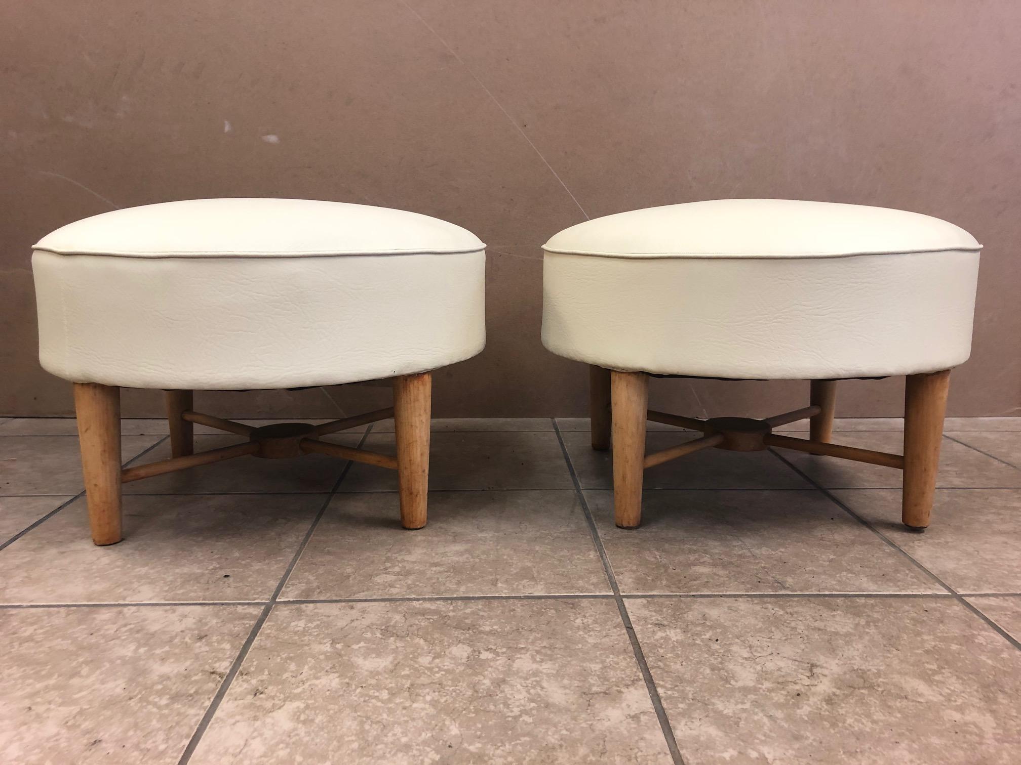 Pair of 1950s, French ottomans. Has a wood X base. Upholstered in leatherette.