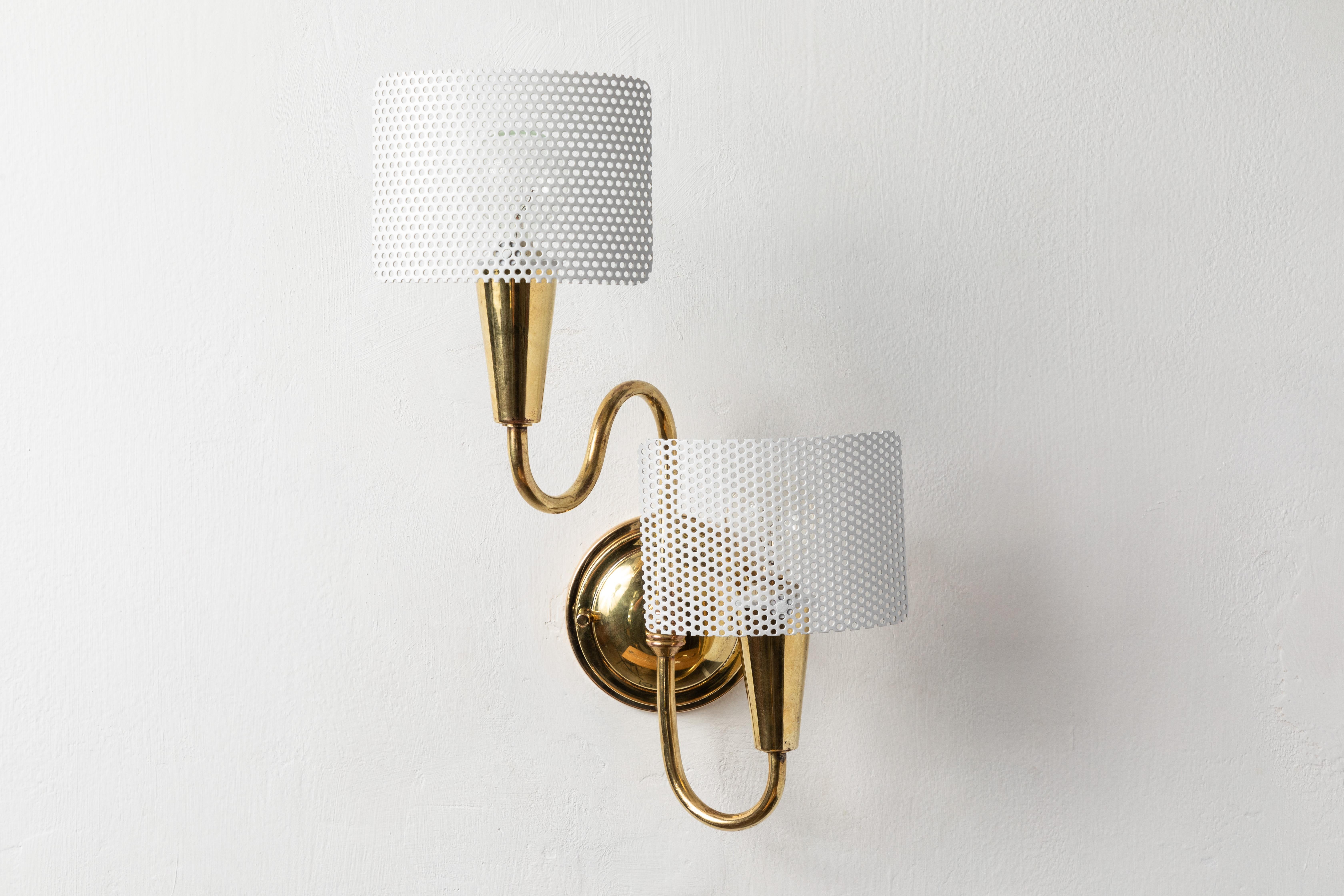 Pair of 1950s French Sculptural Sconces in the style of Mathieu Matégot. Executed in white painted perforated metal and tubular brass. These double shaded sconces embody the more lyrical and warm side of midcentury French design, as exemplified by