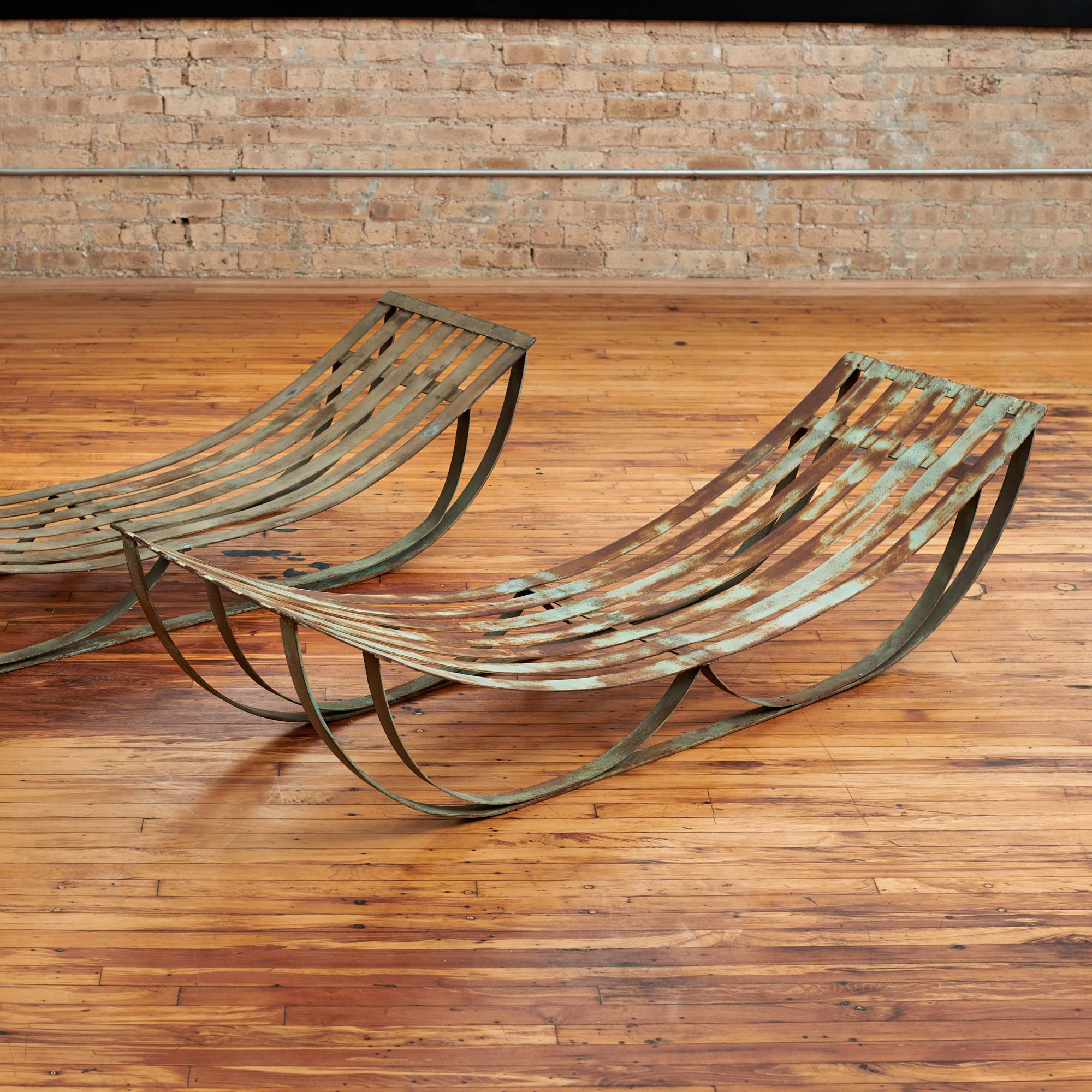 Pair of French sculptural steel lounges, circa 1950s. This fantastic pair retains the original finish which has aged beautifully. The elegantly curved seats look great on their own or could be softened with new upholstery. These pieces of minimalist