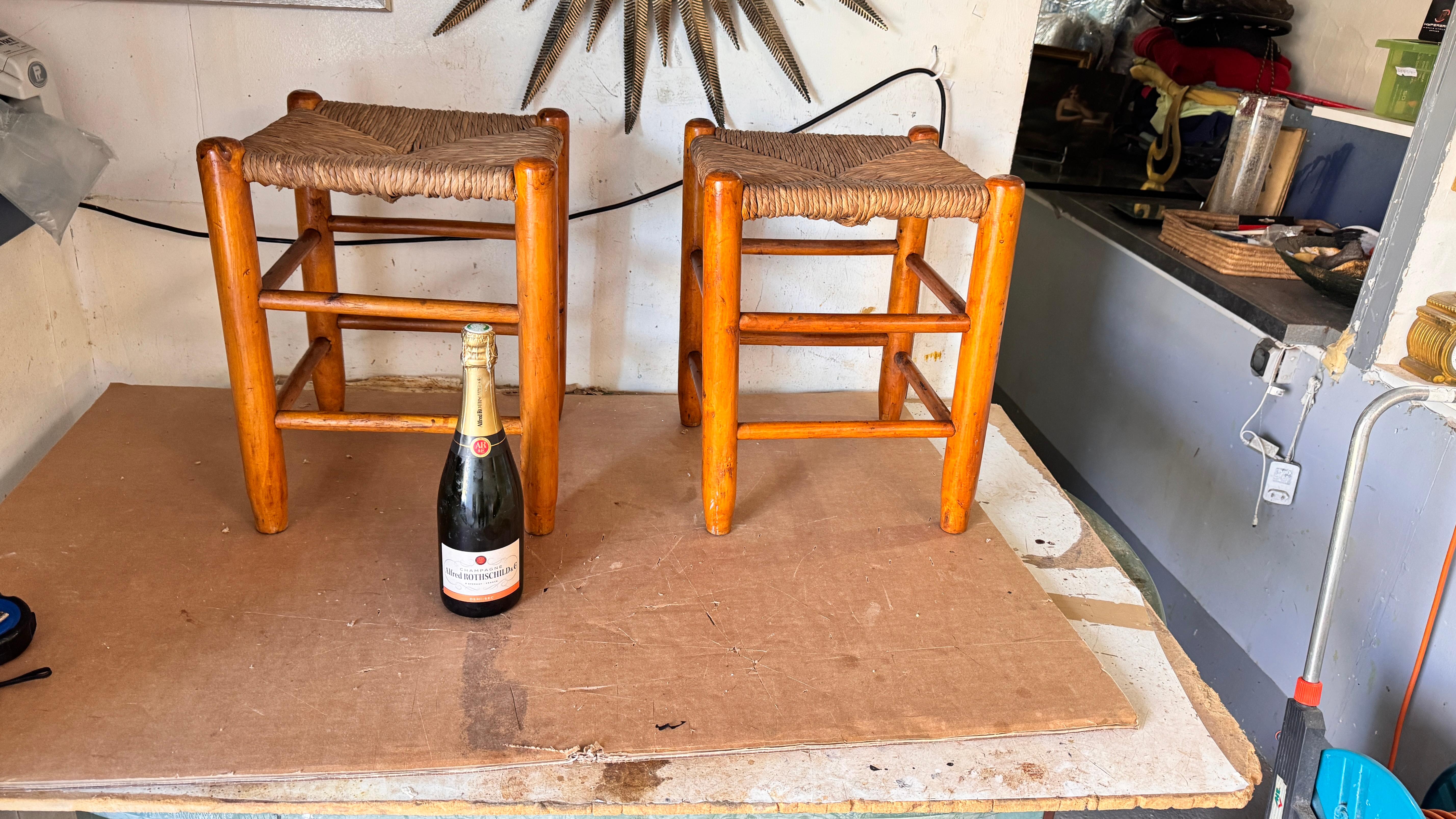 Pareja de taburetes franceses de los a�ños 50 al estilo de Charlotte Perriand - Asientos de madera y paja tejida

Descripción:
Este par de taburetes franceses de los años 50 están fabricados con el inconfundible estilo rústico asociado a Charlotte