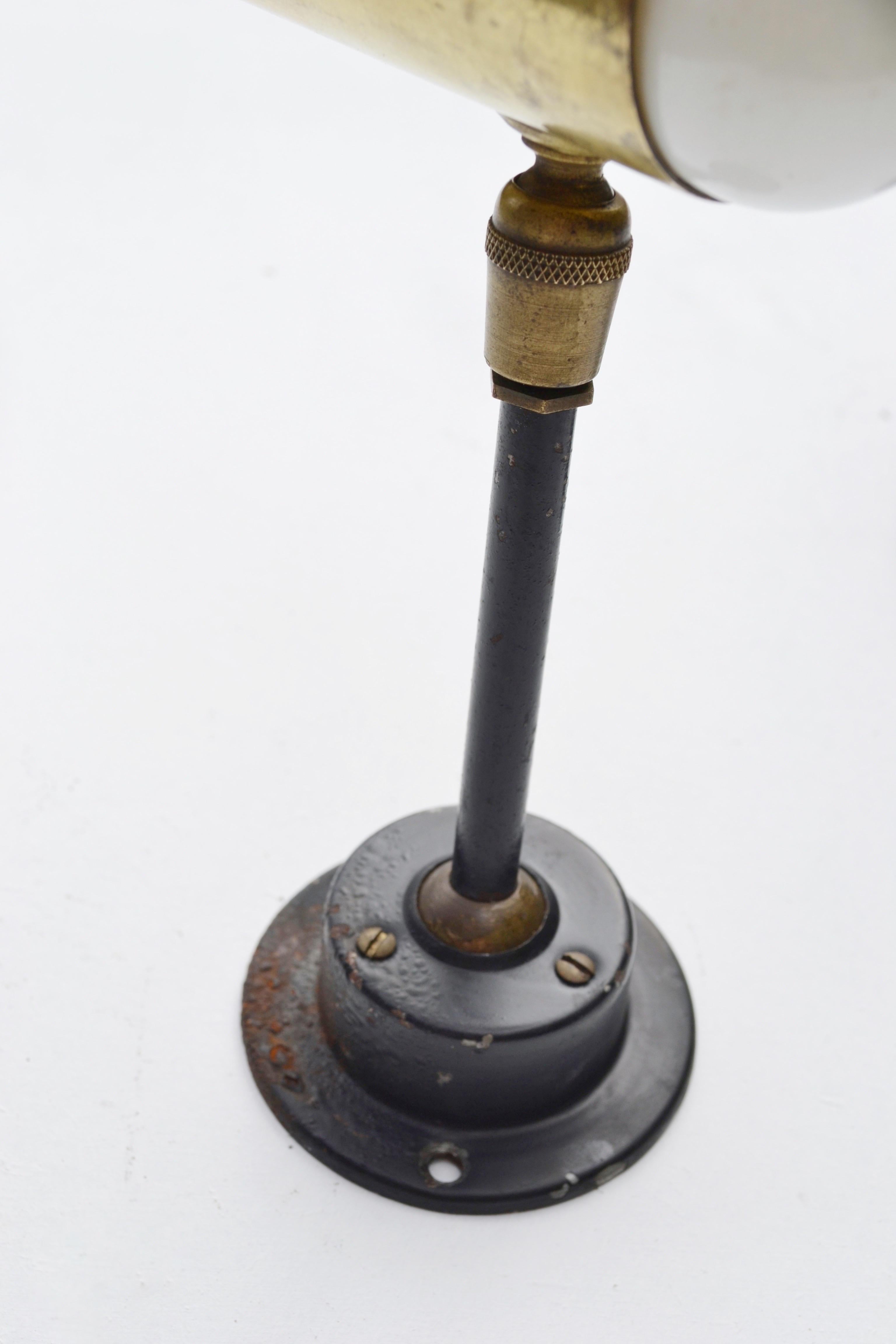 Pareja de elegantes apliques franceses de los años 50, diseñados según el espíritu de Jean René Caillette, con estructura de metal lacado en negro y pantalla tubular de latón. El diseño minimalista e industrial se ve realzado por un sistema de doble