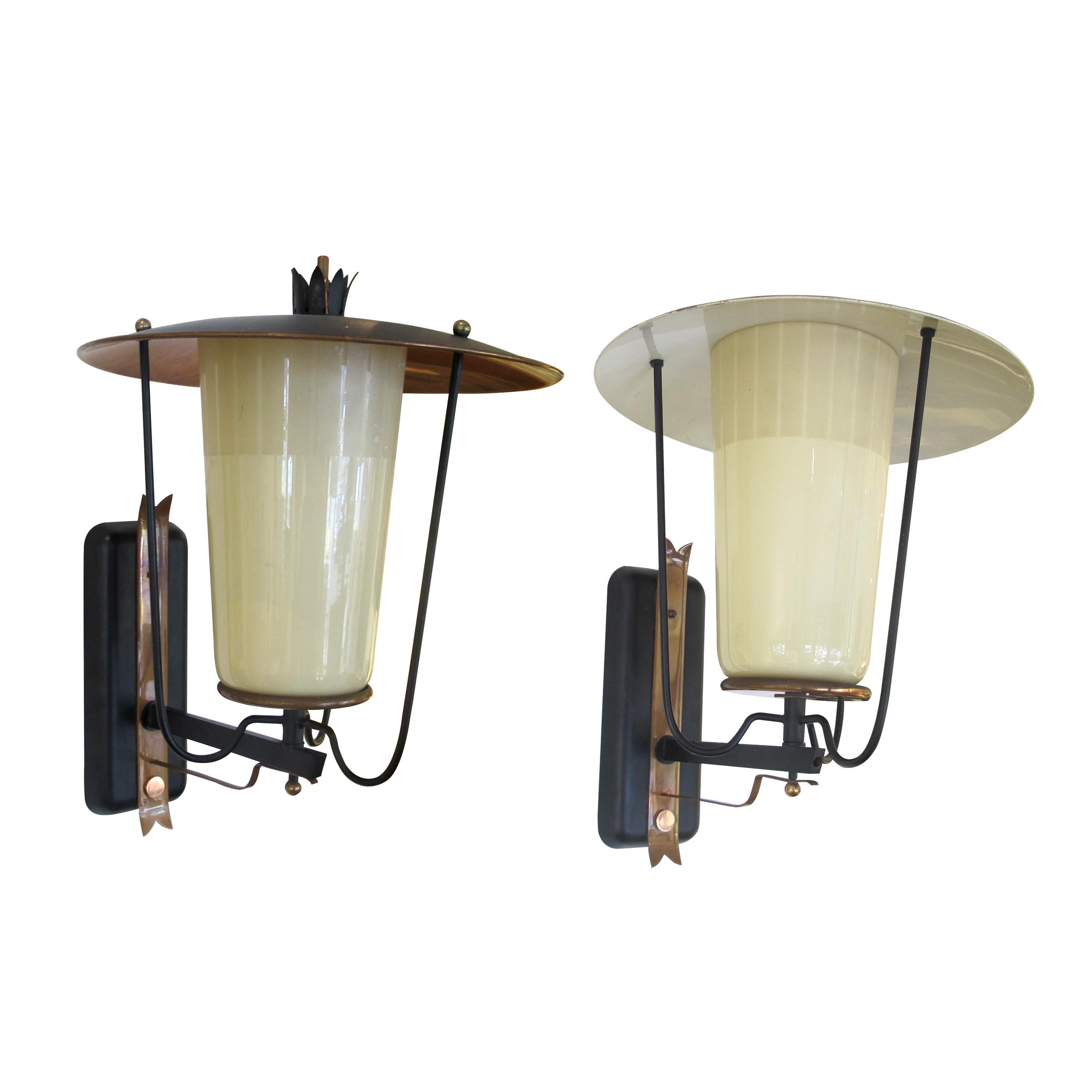 Pair of French 1950s wall-mounted lanterns which effortlessly blend style and functionality which will bring a touch of vintage charm to any space, whether used to illuminate a hallway, flank an entryway, or enhance the ambience of an outdoor patio.