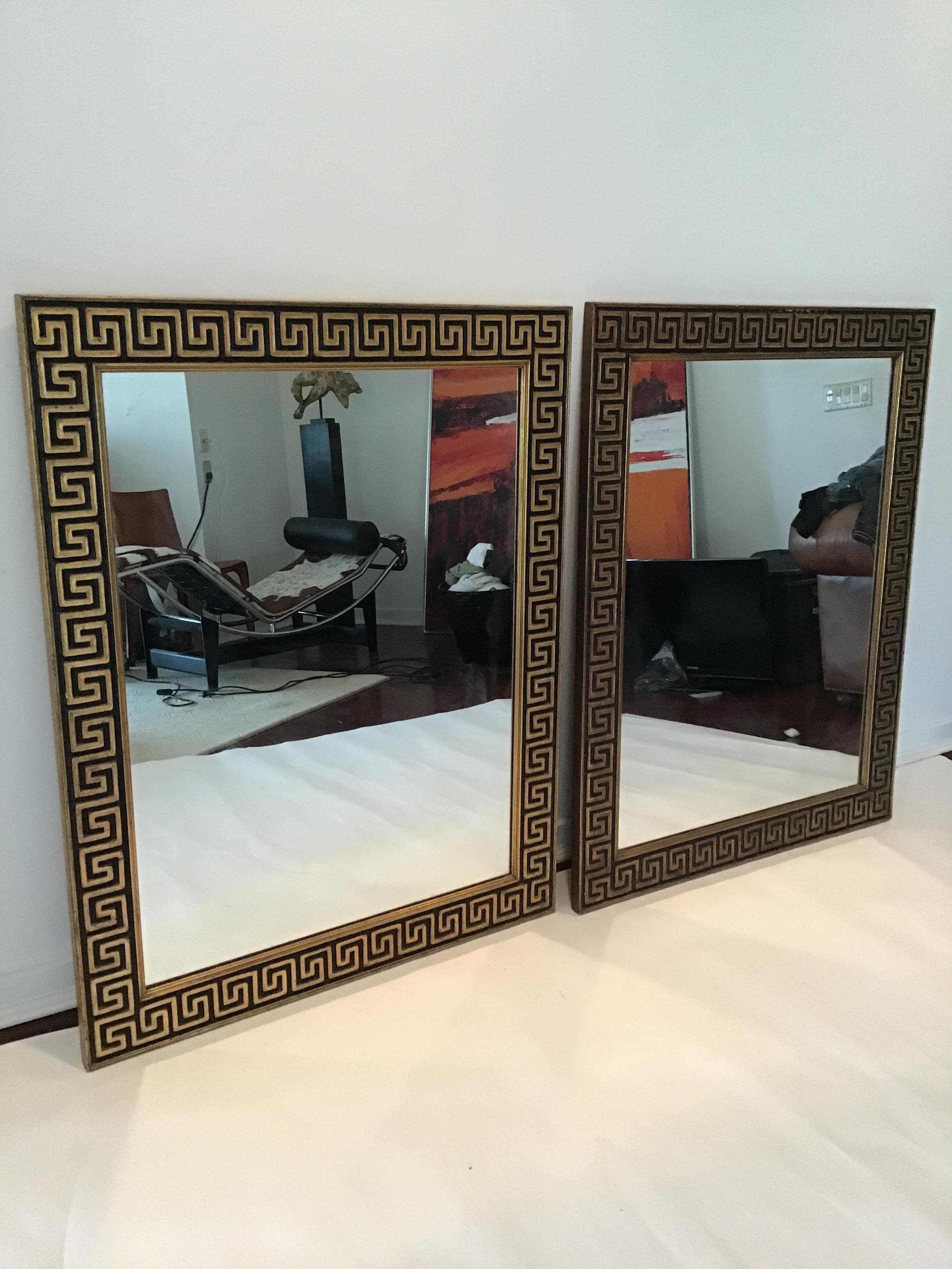 Paire de miroirs à clé grecque encadrés en bois doré.