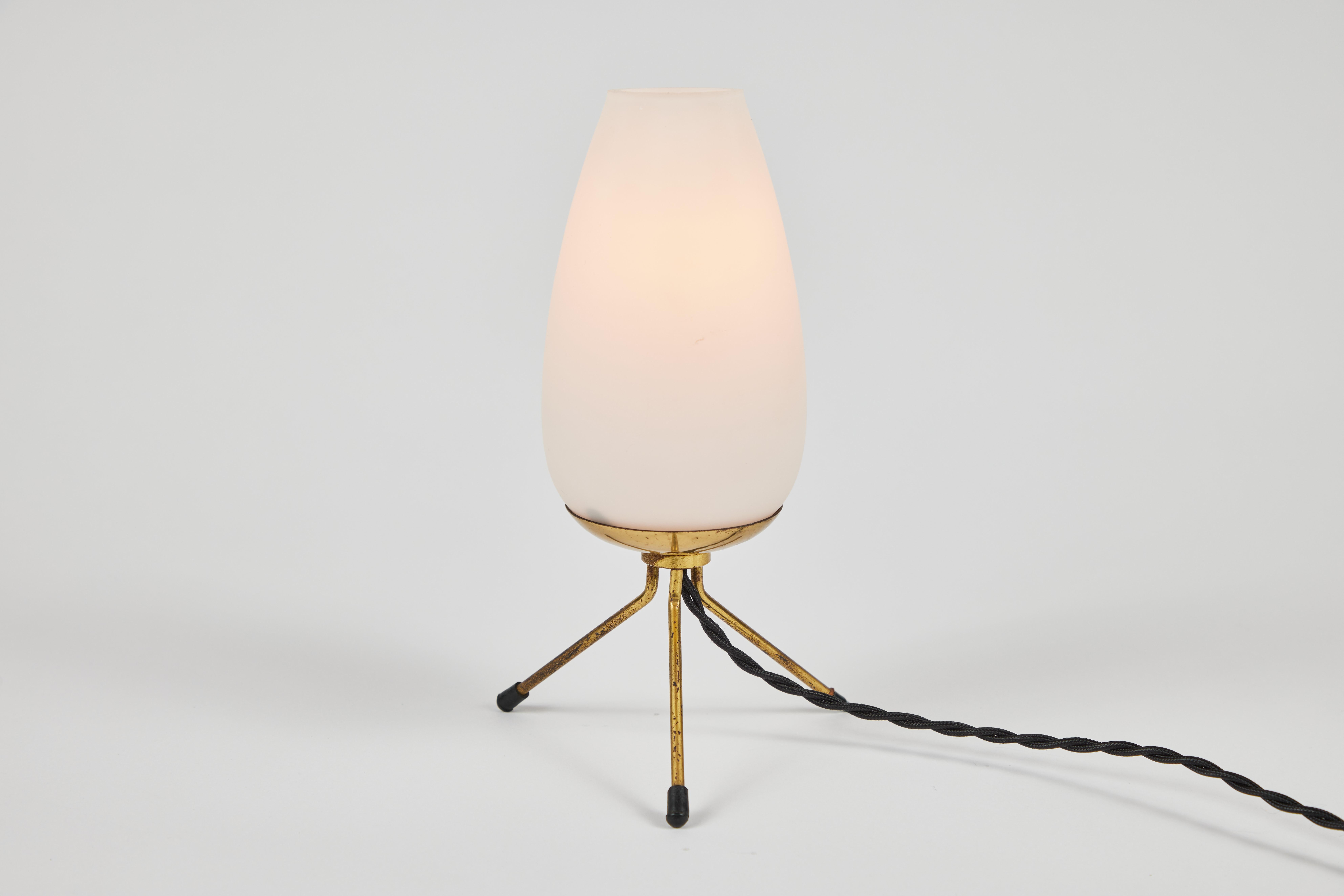 Pair of 1950s glass and brass tripod table lamps attributed to Stilnovo. Executed in thick opaline glass with brass tripod legs. A sculptural and refined design characteristic of 1950s Italian lighting at its highest level.

Price is for the