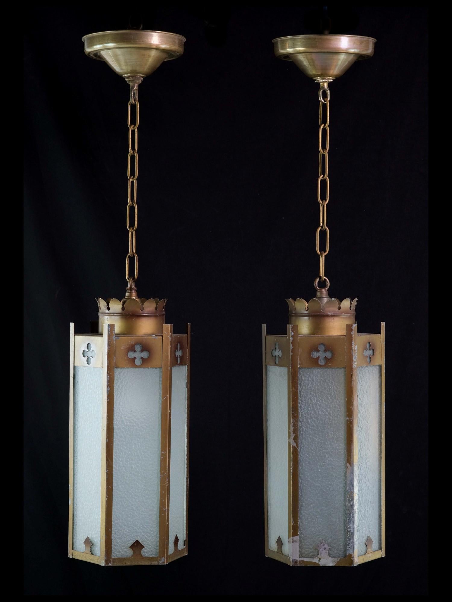 1950's Gothic style pendant lights with textured white glass. This pair of hexagon shaped steel lights with brass plating have the original patina although there some wear with the brass (see pictures). Priced as a pair. This can be seen at our 400