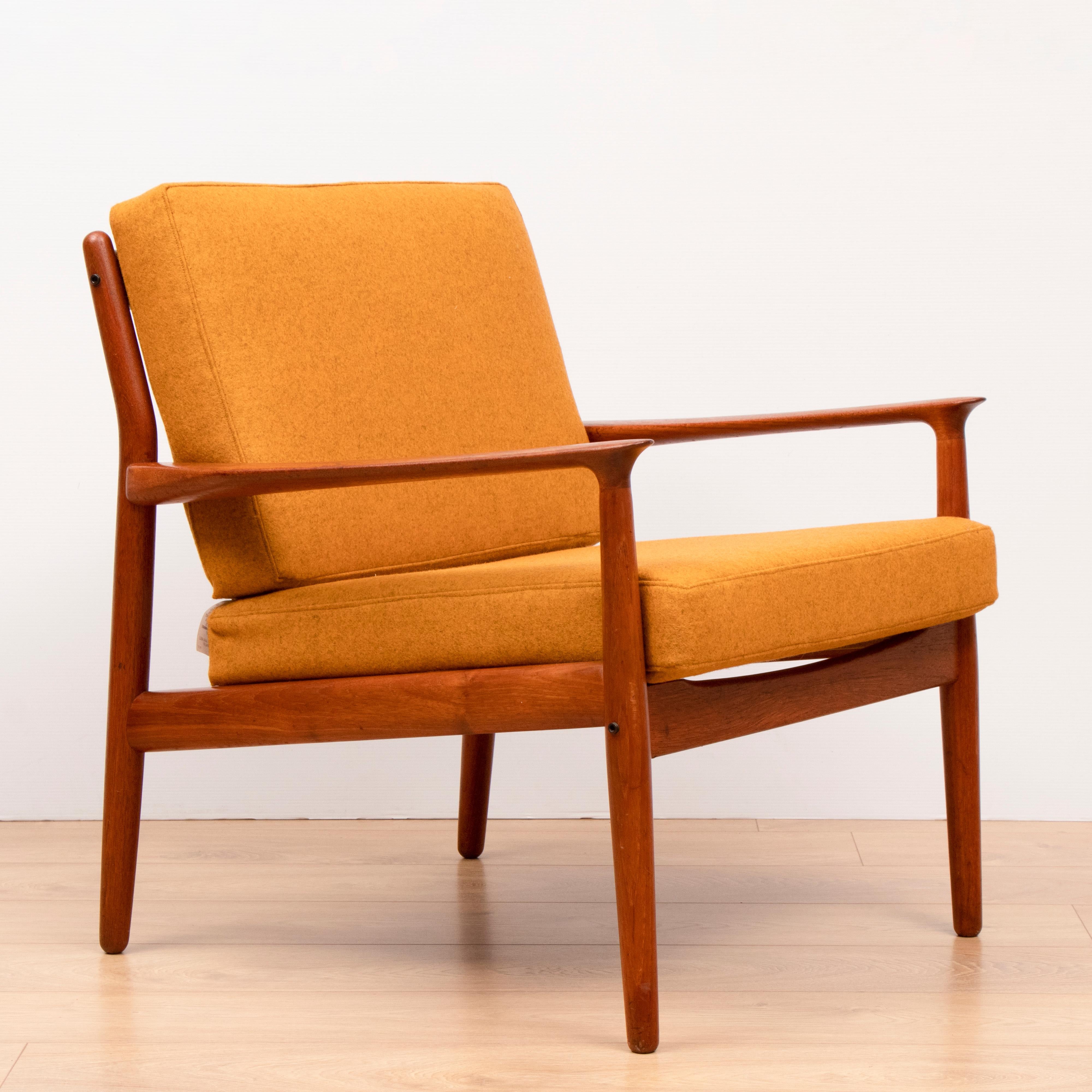 Pair of Grete Jalk solid Teak lounge armchairs re-upholstered in a mustard yellow wool fabric. The chairs were manufactured in Denmark by Glostrup Møbelfabrik during the 1950s. This specific model is one of the most sought after incorporating a