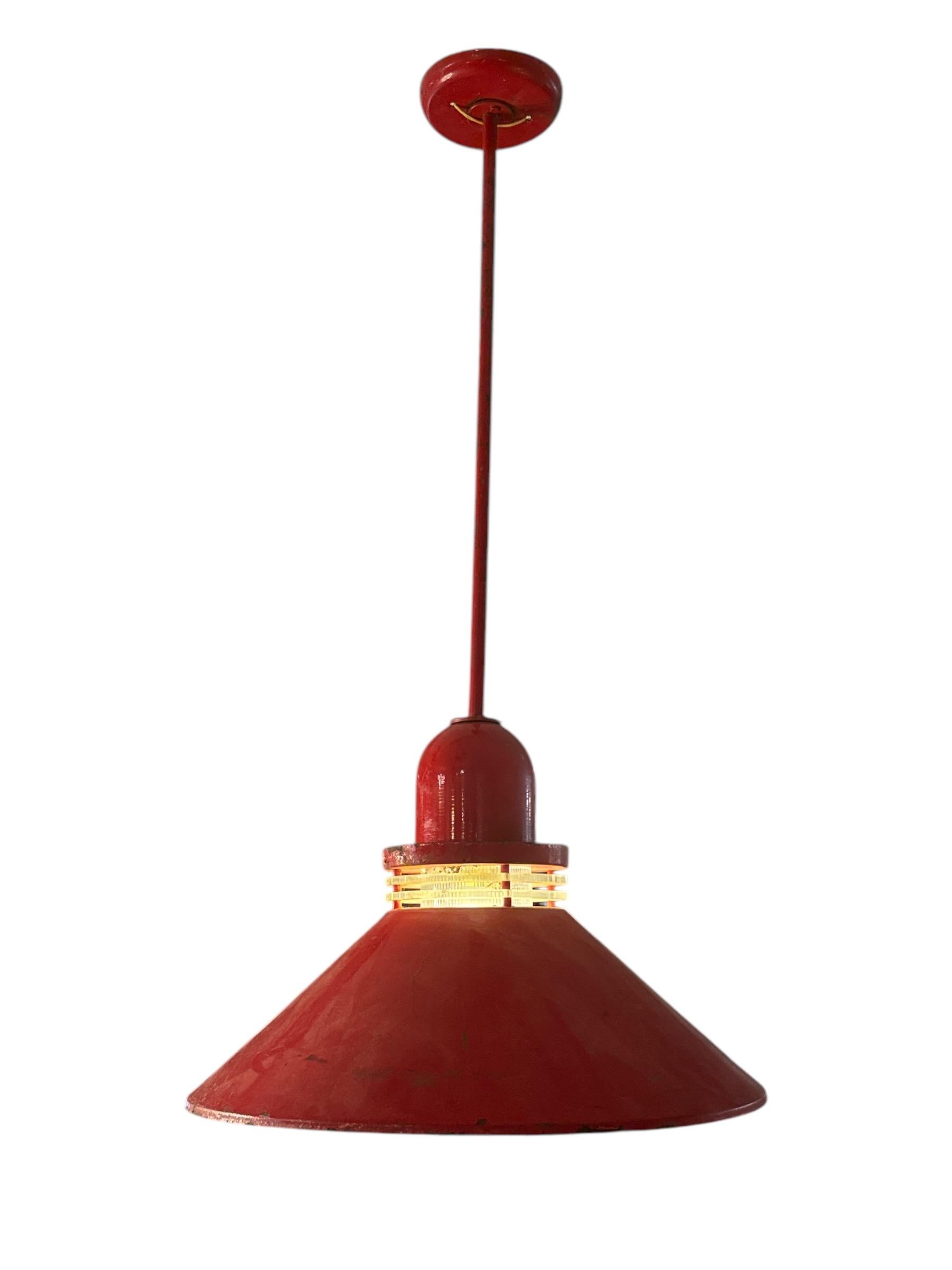 Infondi nel tuo ambiente un fascino vintage e un carattere deciso con questa splendida coppia di lampade a sospensione industriali a smalto rosso degli anni '50. Queste lampade a sospensione catturano l'essenza del design industriale del dopoguerra,