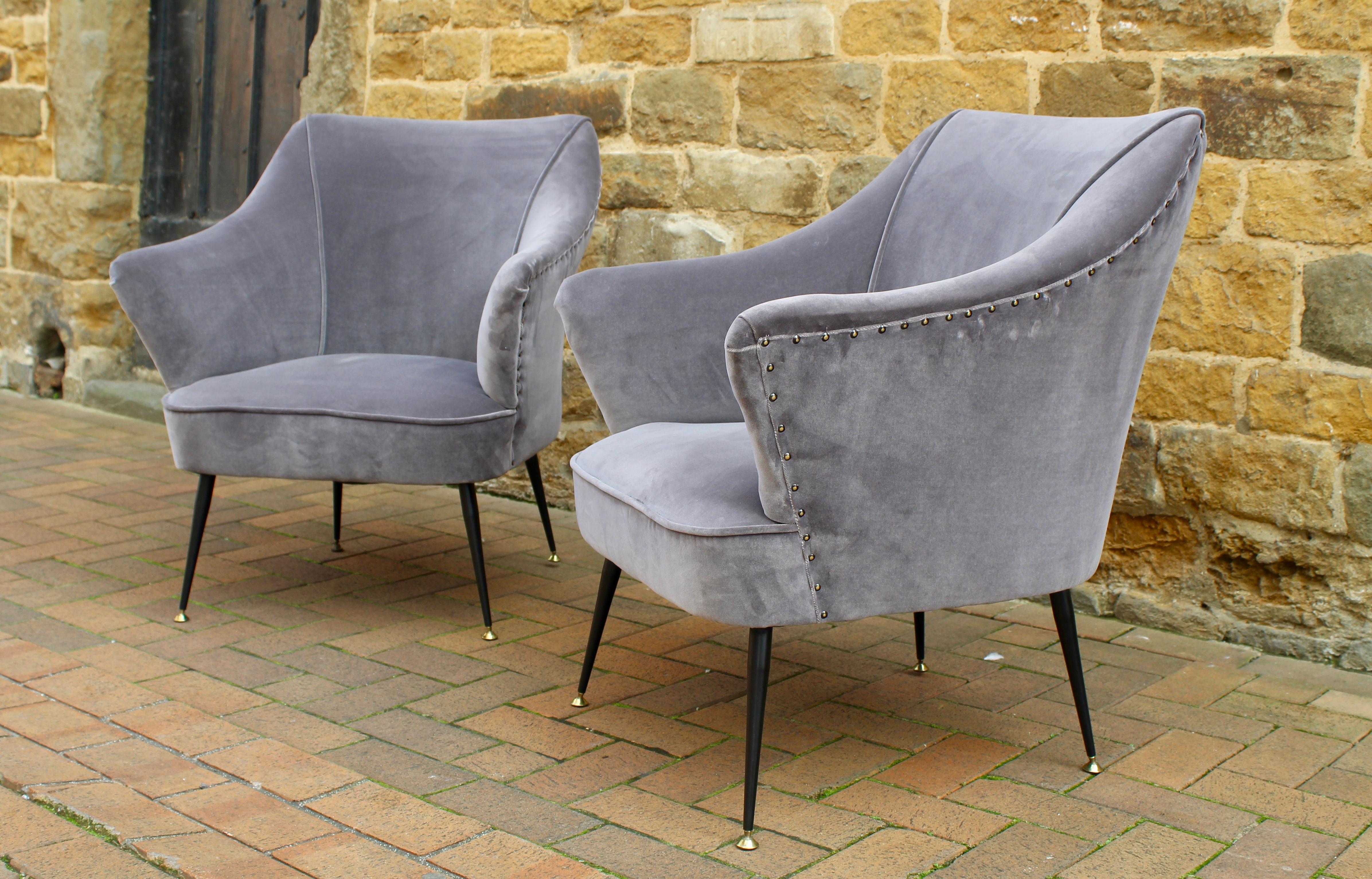 Beautiful pair of 1950s Italian armchairs attributed to Gio Ponti which have been recently reupholstered in a high quality grey velvet. These chairs sit on tall thin black steel legs with brass feet. 

Dimensions:
Height 80 cm
Seat height 40