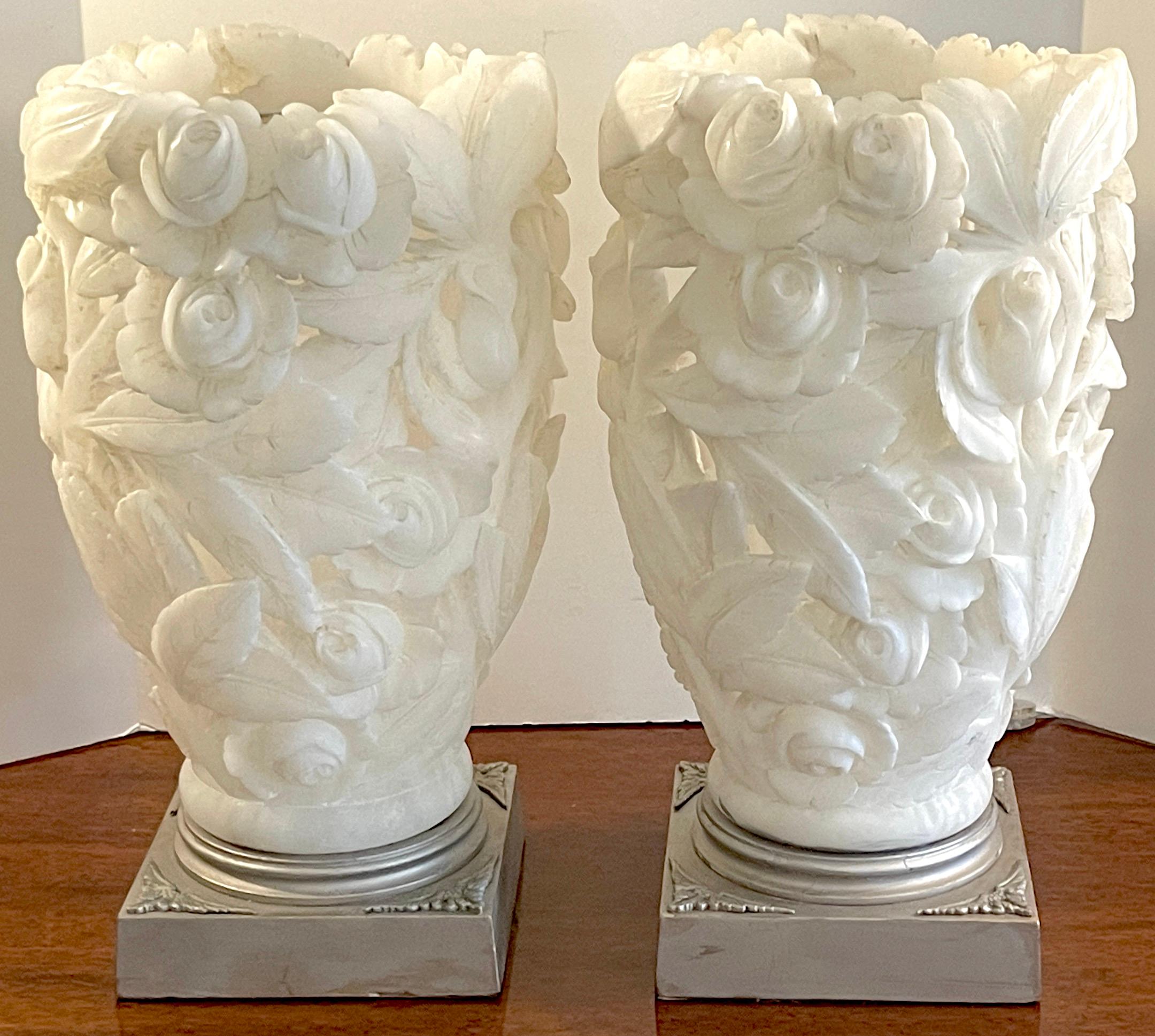Pair of 1950s Italian carved Alabaster Rose Motif torchere lamps 
Each one fantastically hand-carved in pierced relief, raised on 8-inch square silver-leaf pedestal base. Unsigned.
Shown when light in the photos with a dimmer, numerous options for