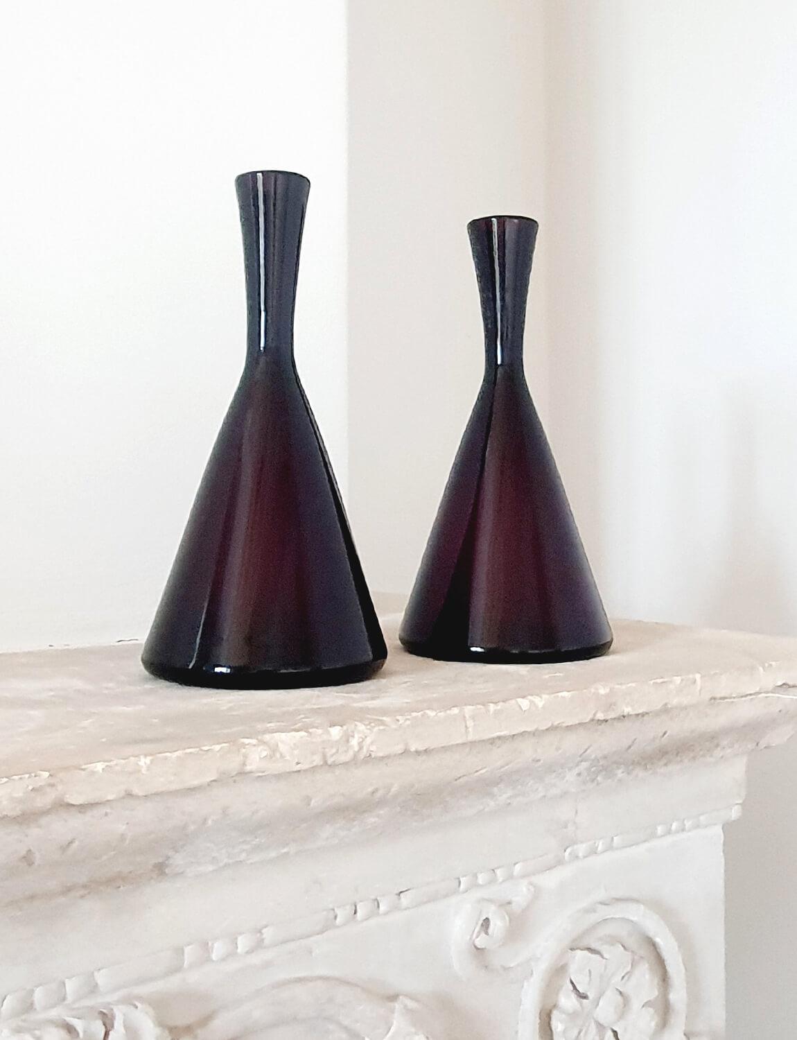 A pair of Italian hand-blown Empoli Glass wine bottles made in a cranberry coloured (dark purple) glass. These exceptional bottles were hand-blown in Empoli in the 1950s. In the last century Empoli in Tuscany was one of the most famous glass-blowing