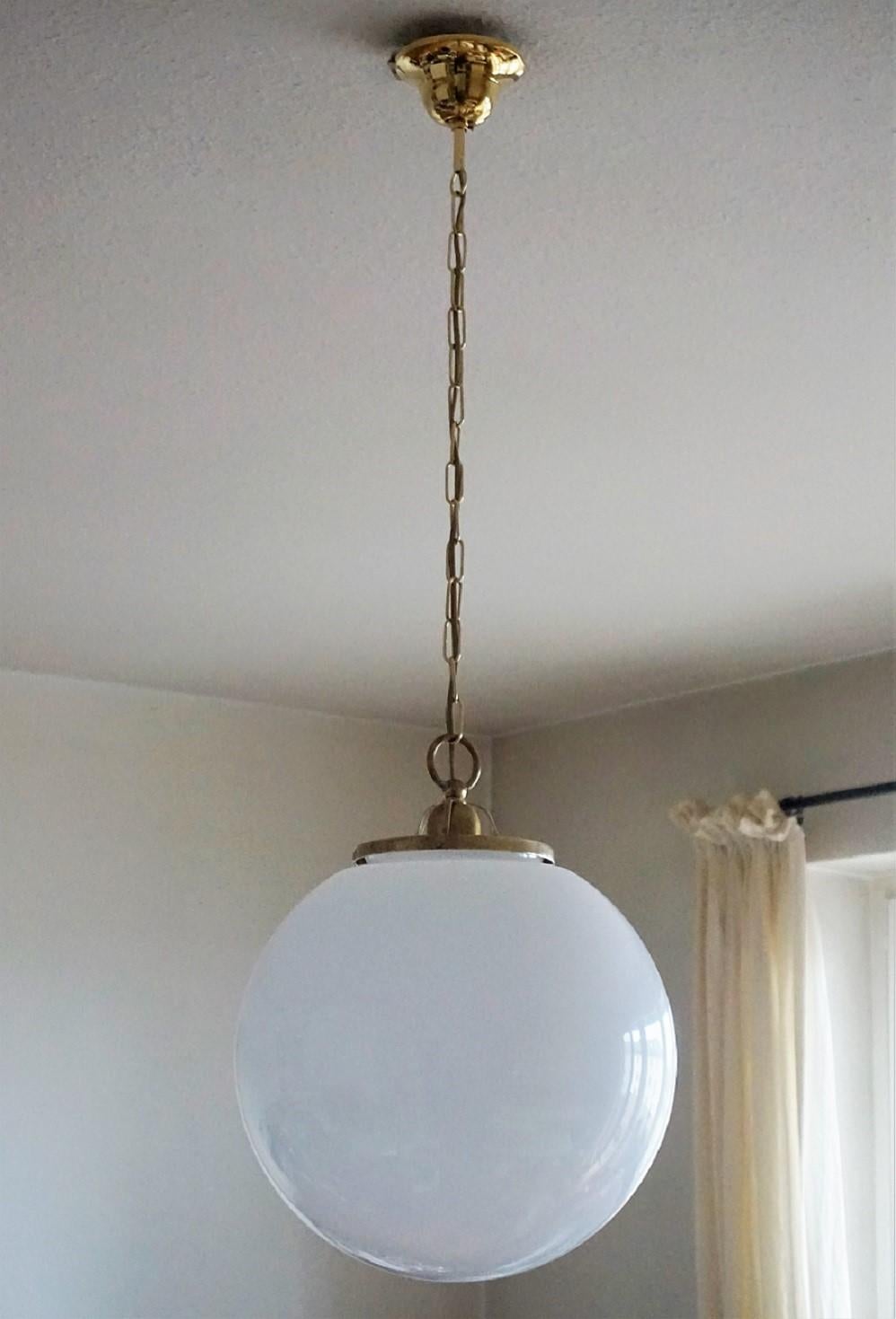 pair of large hand blown opaline glass ball pendants, brass-mounted with a single E-27 light socket for a large sized bulb, 1950s.
Measures: Diameter 14