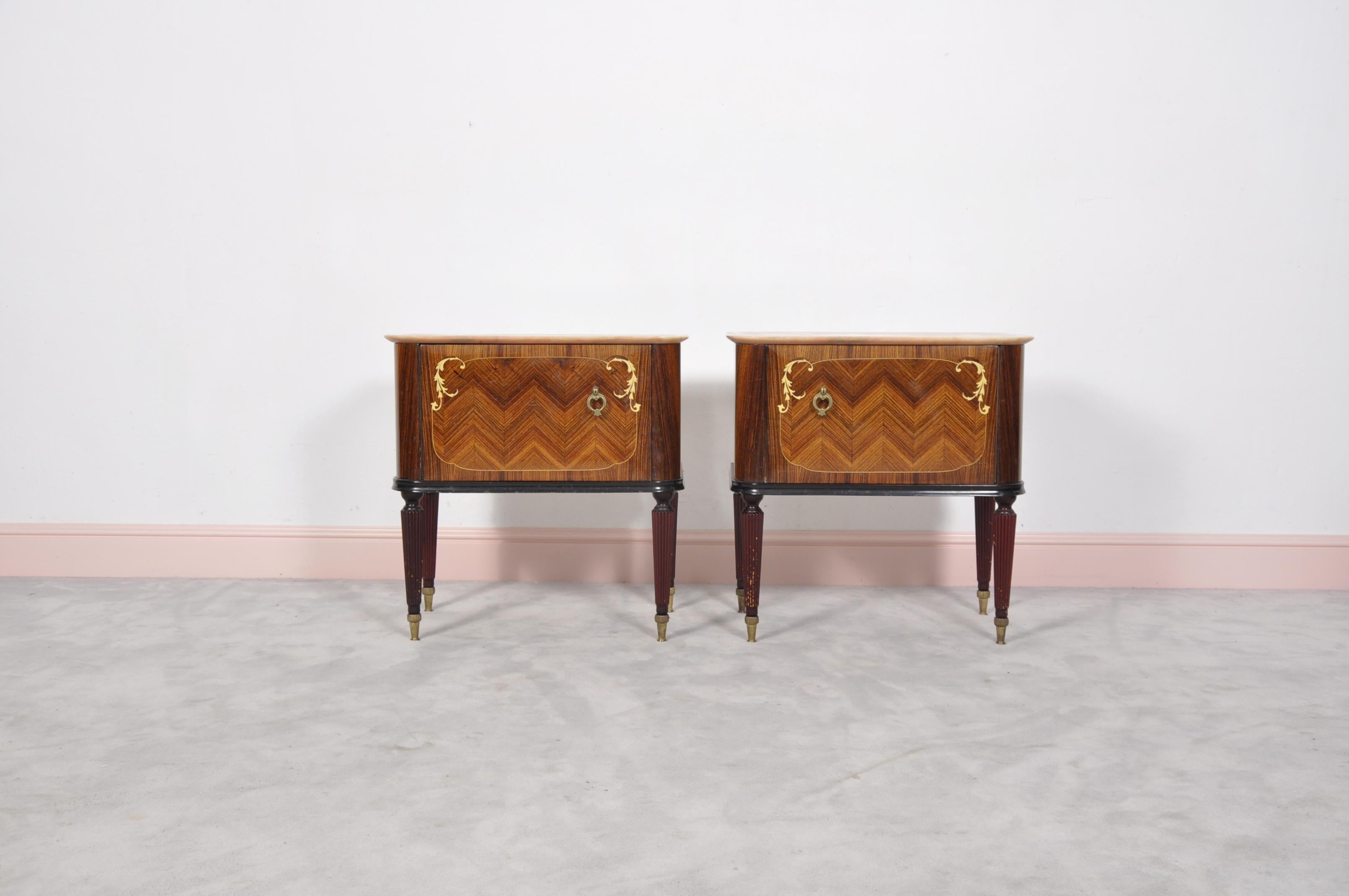 A set of two beautifully carved nightstands or side tables executed in fine rosewood. The marble tops perfeclty fit with the wood. The leg ends are finished with lightly patinated copper sabots. The size is typical, considering that nightstands are