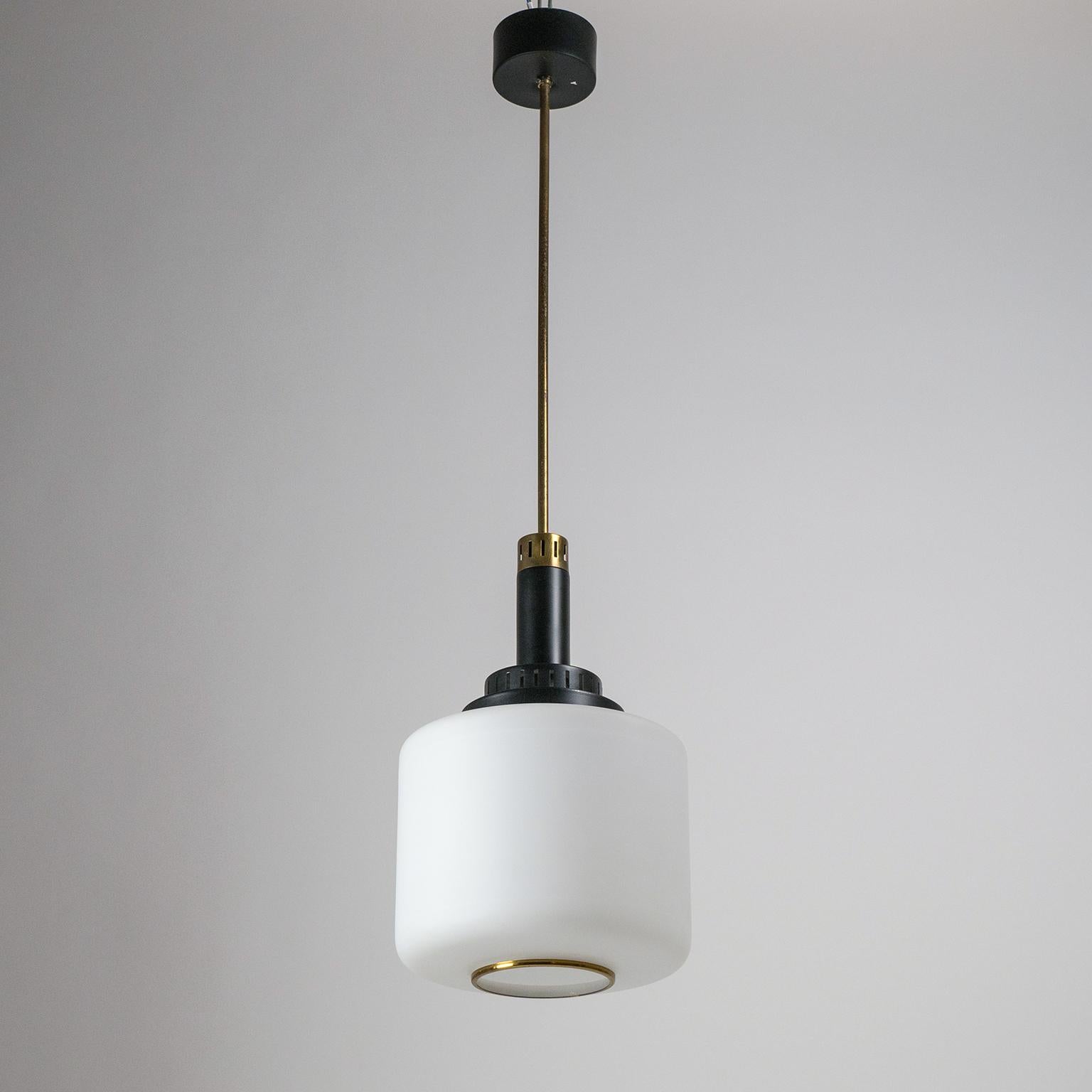Classic midcentury Italian pendants by Stilux. They have good sized satin glass diffusers, brass details and tiered and pierced aluminium elements in black. Both are in very good original condition with minimal loss of original paint and a nice