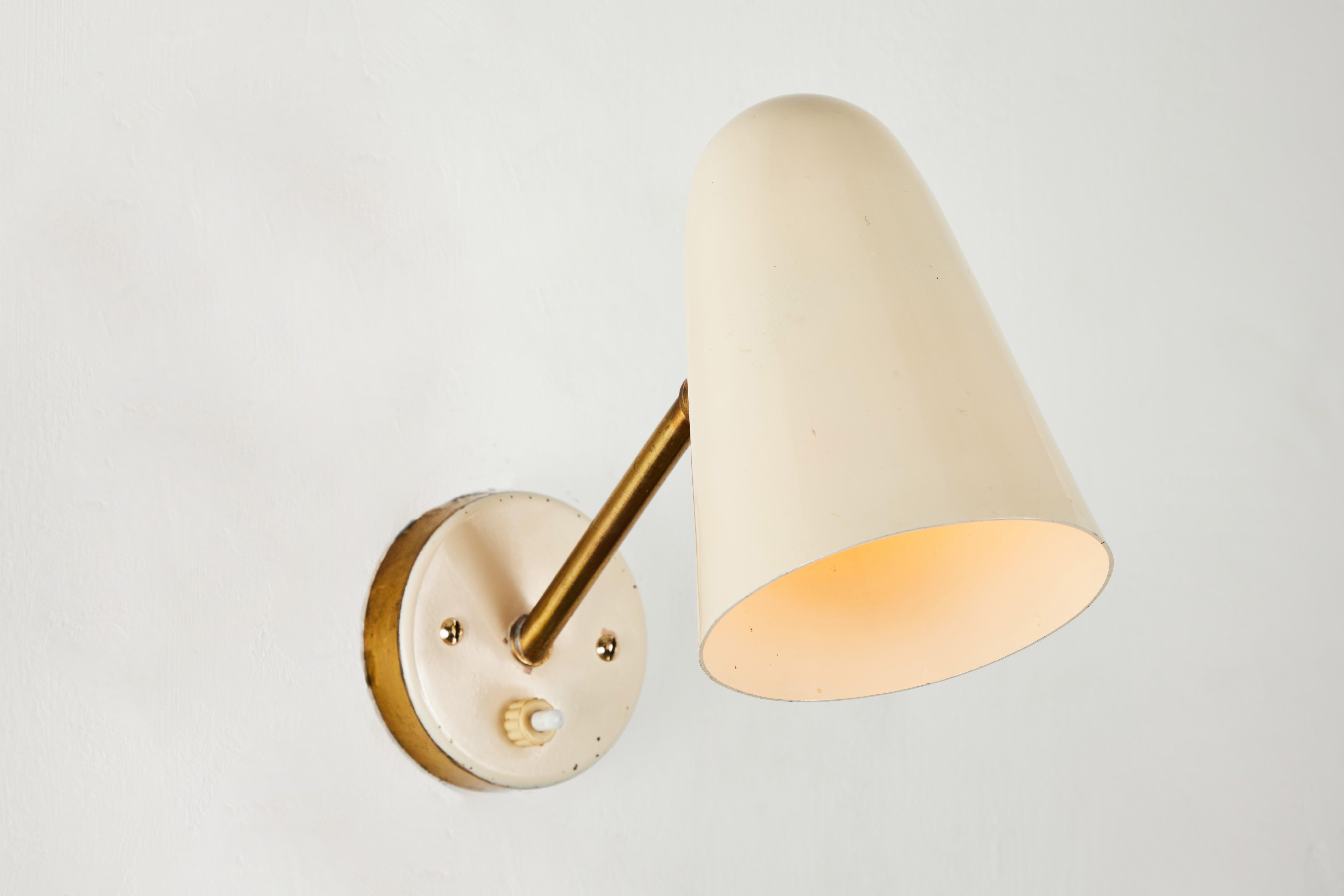 Pair of 1950s Italian sconces attributed to Gino Sarfatti. Executed in brass and original lacquered white aluminum. Sconces pivot 360 degrees up/down and left/right on a ball joint. Original on/off push switch in backplate. Accommodates a single US