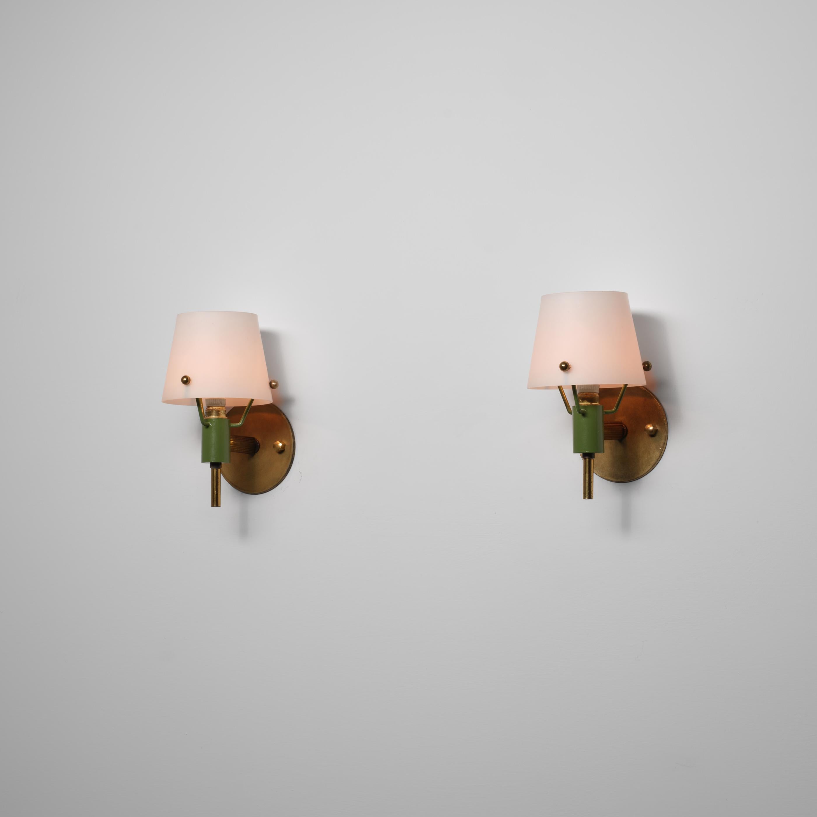 Zwei italienische Wandleuchten aus den 1950er Jahren aus Messing mit natürlicher, gealterter Patina in Kombination mit grün lackierten Metallakzenten. Die Opalglasdiffusoren haben ein sanft auslaufendes, konisches Profil, das unten breiter ist und