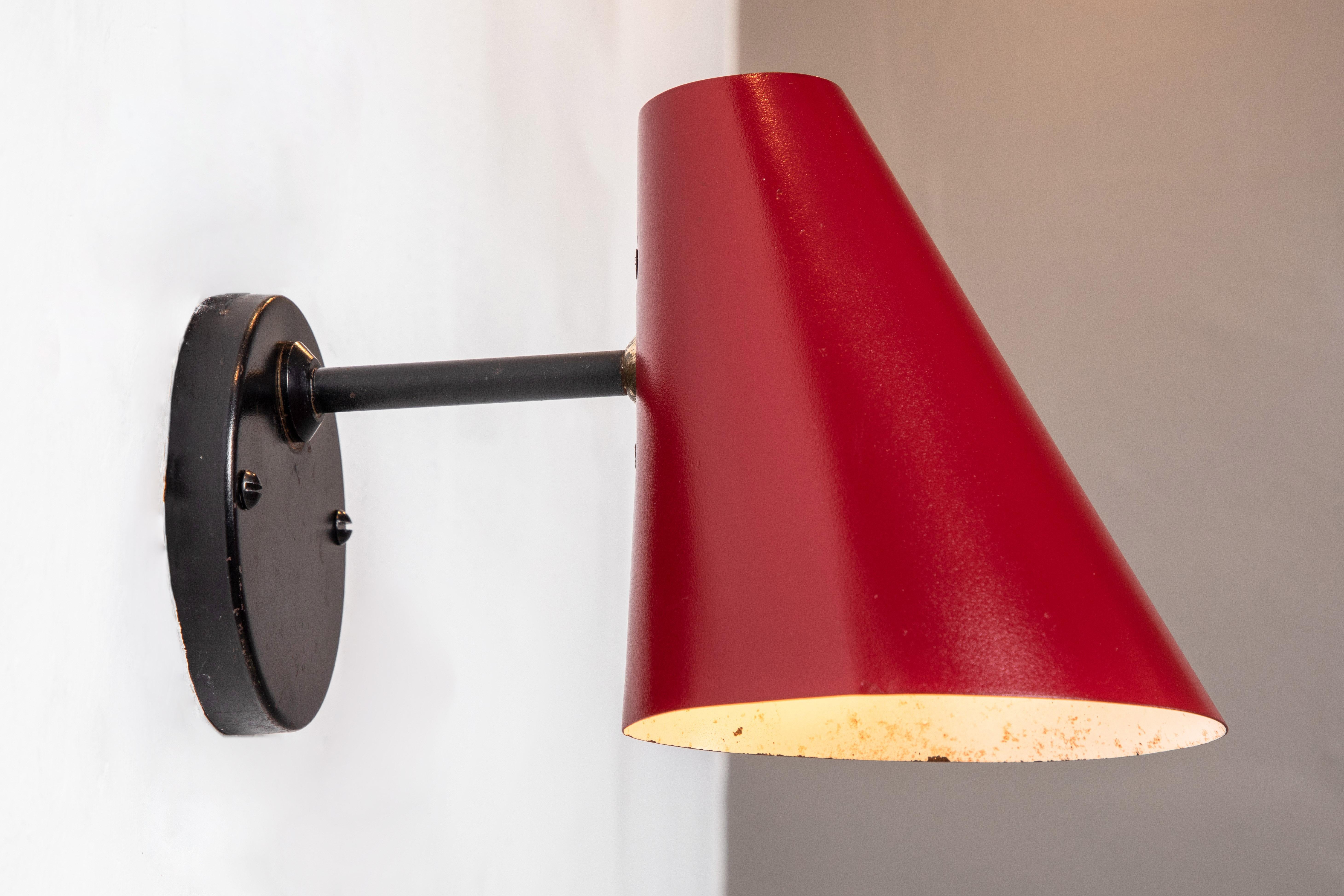 Pair of 1950s Jacques Biny Red & black wall lights. A exceptionally clean and simple design executed in red and black painted metal. Lamps rotate freely on adjustable swivel. Quintessentially midcentury French in its conception and
