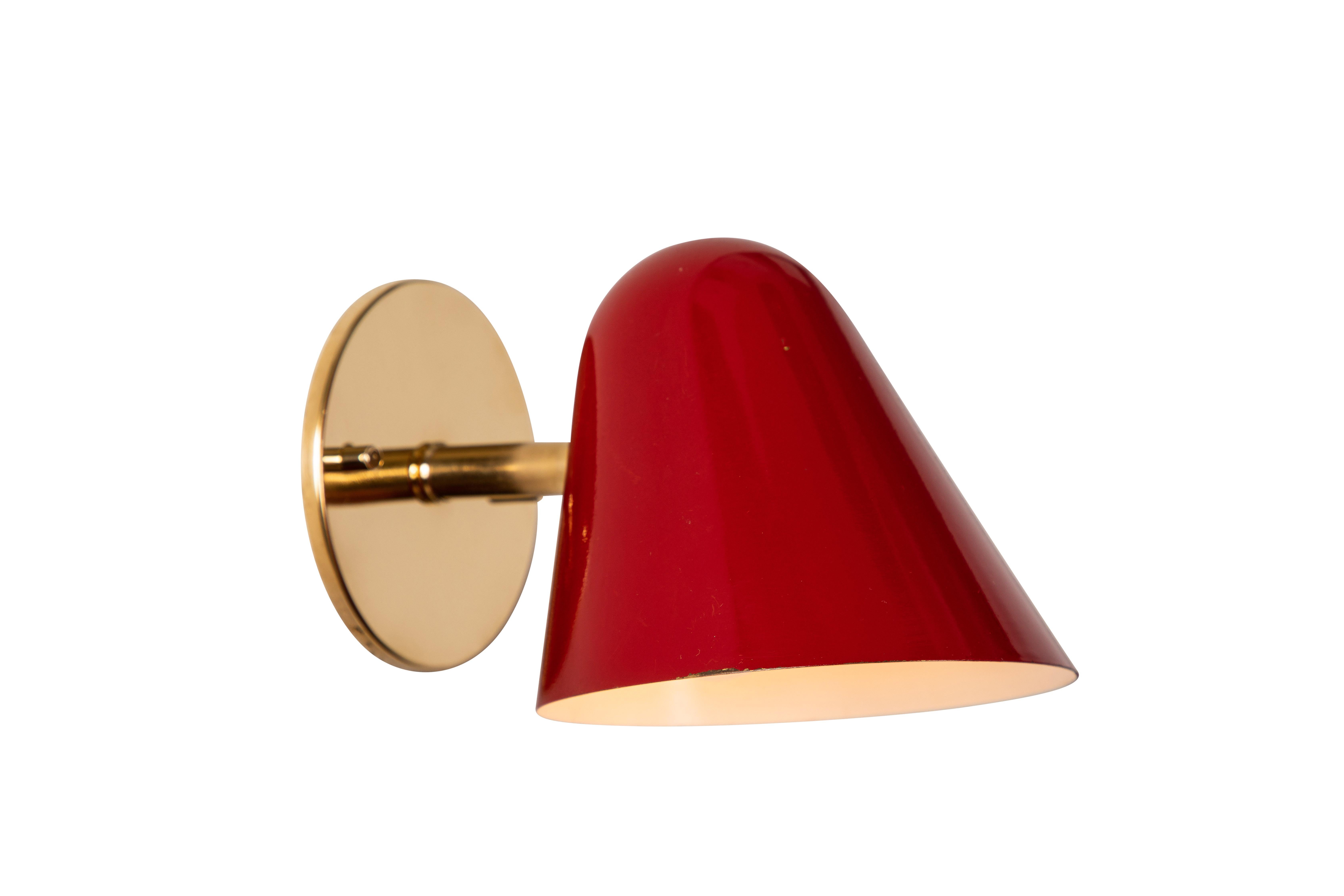 Pair of 1950s Jacques Biny red wall lights. A exceptionally clean and simple design executed in brass with red painted metal shade. Lamps rotate freely on adjustable swivel. Quintessentially midcentury French in its conception and