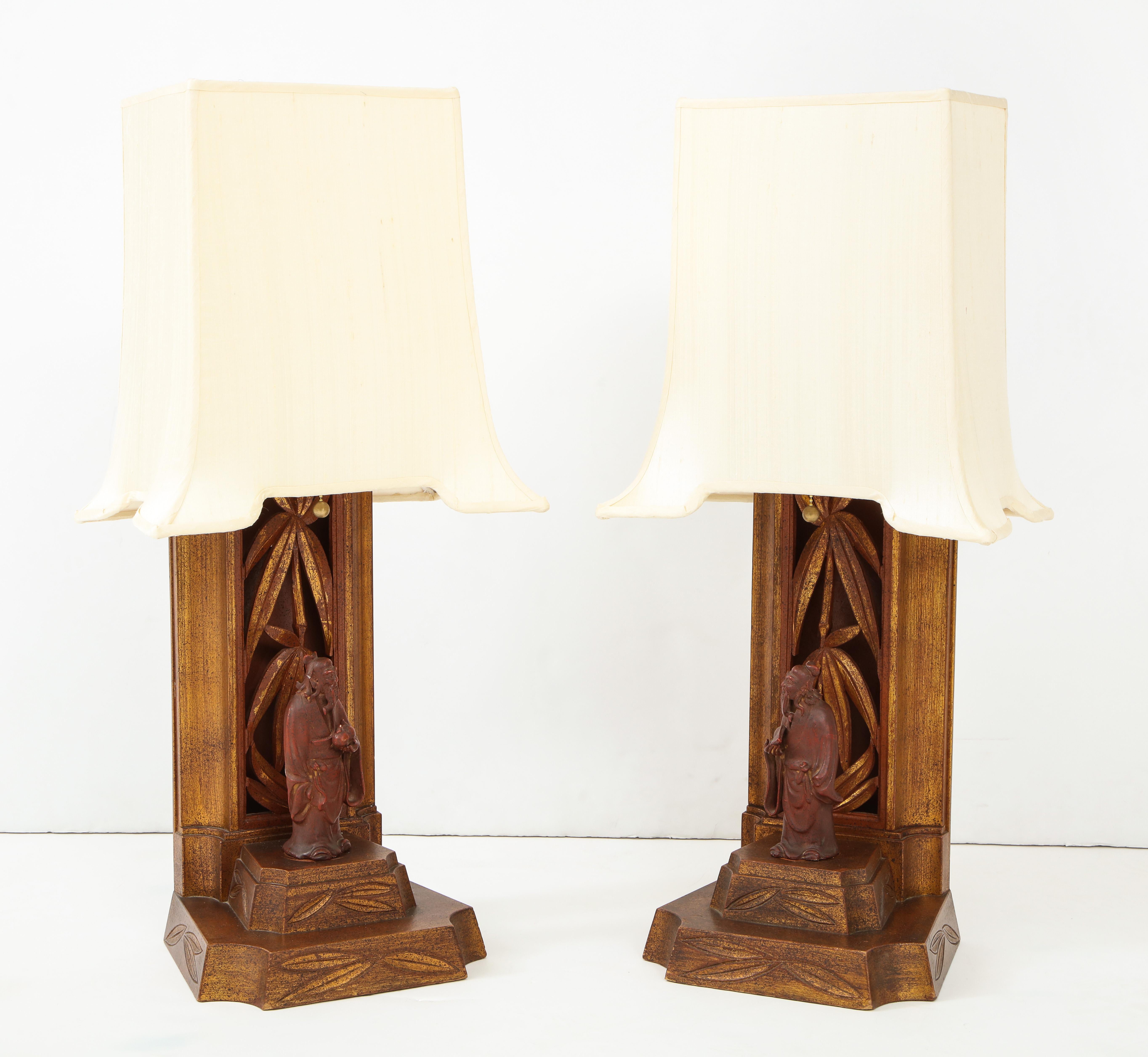 Wonderful pair of 1950s hand carved Chinese figurine lamps by
James Mont.
The cinnabar lamp bases and figurines are decorated with gold leaf.
The lamps have been newly rewired and come with the original pagoda shades which have also been newly