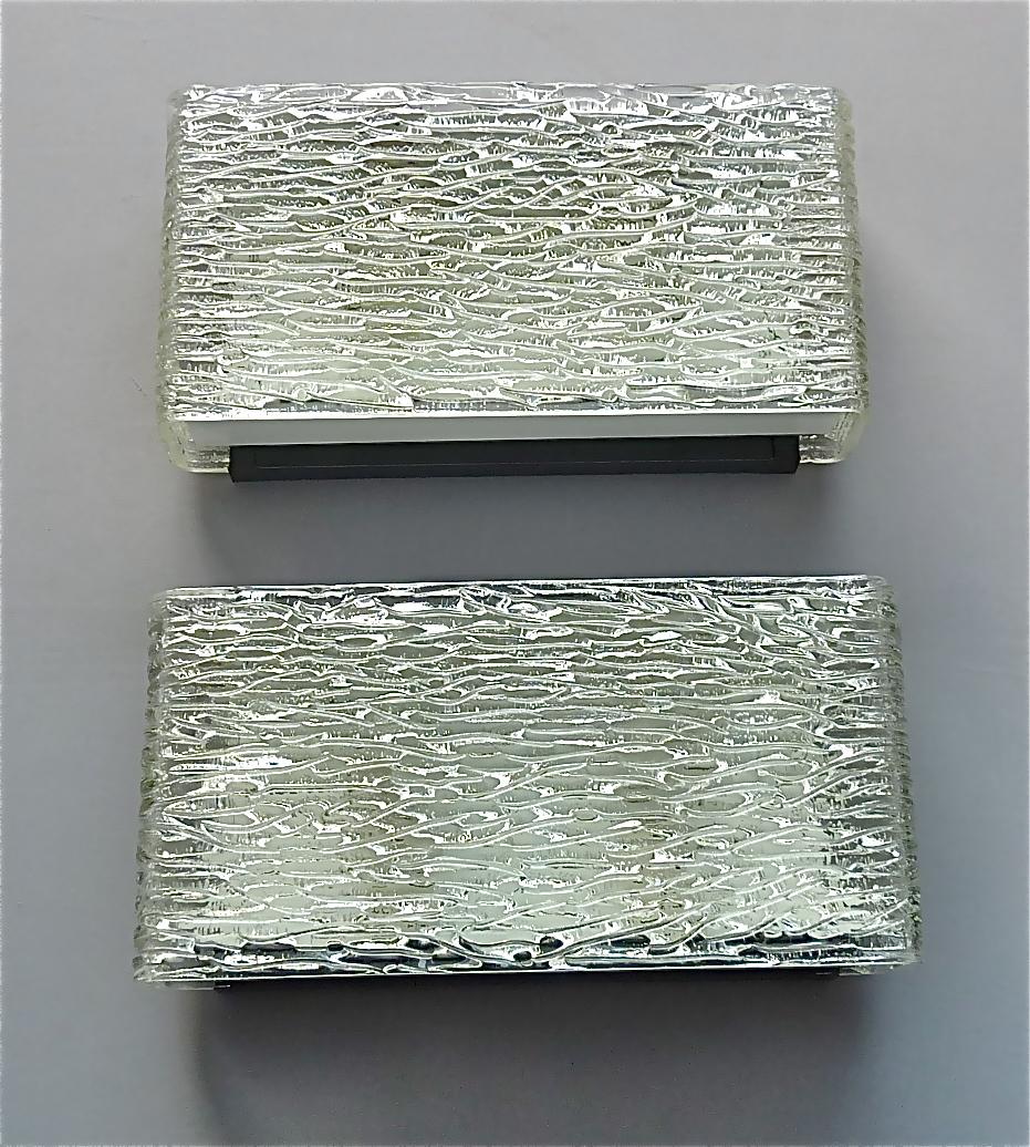 A cool pair of Mid-Century Modern Kaiser textured Murano glass wall lights or sconces, Germany circa 1950-1960. They have a black and white enameled base, each two porcelain fittings for two E14 standard screw bulbs to illuminate, and two bent