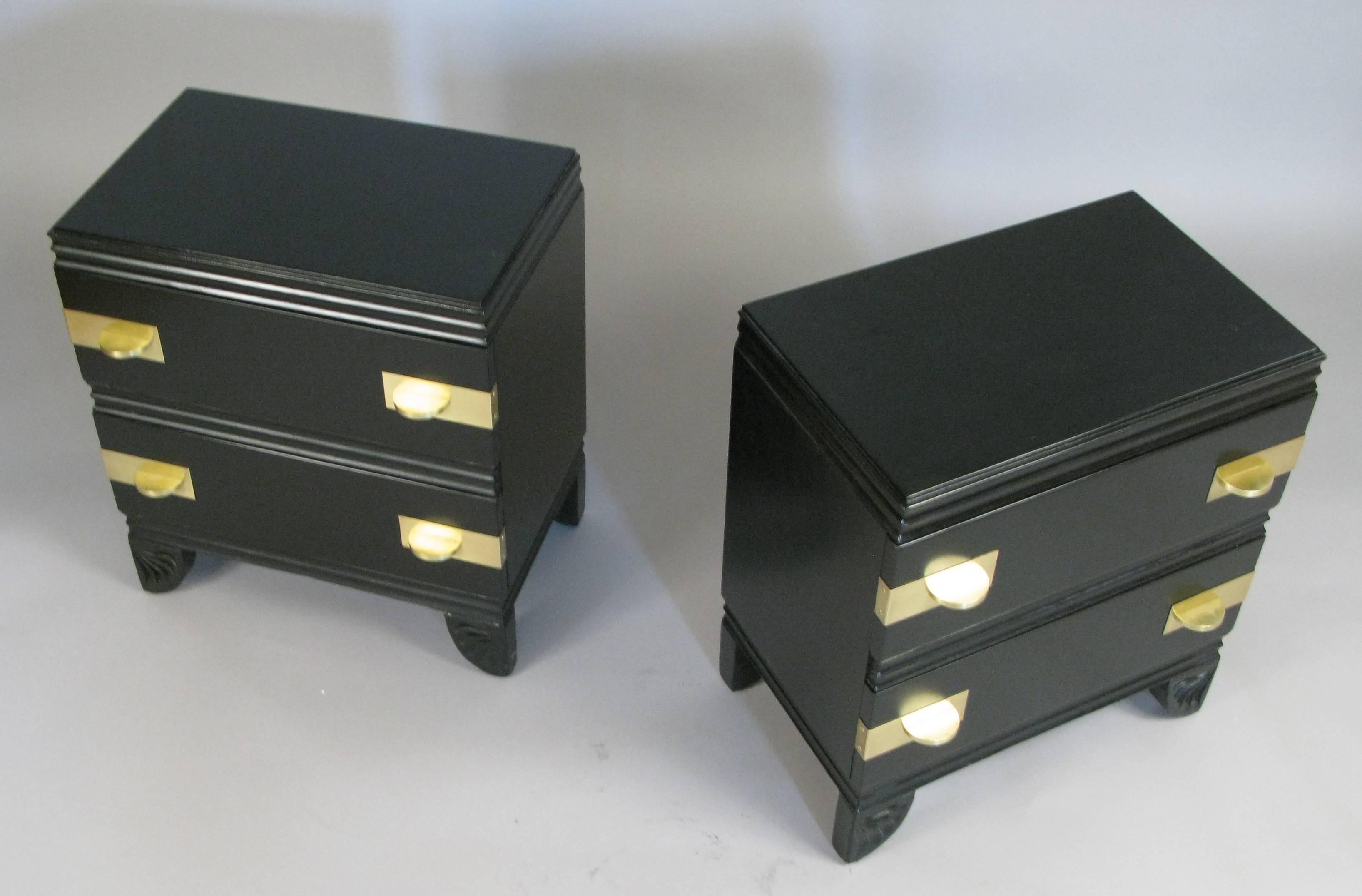 A pair of two-drawer 1950s nightstands in black lacquer with amazing large polished brass hardware and carved fluted feet. Beautiful details!