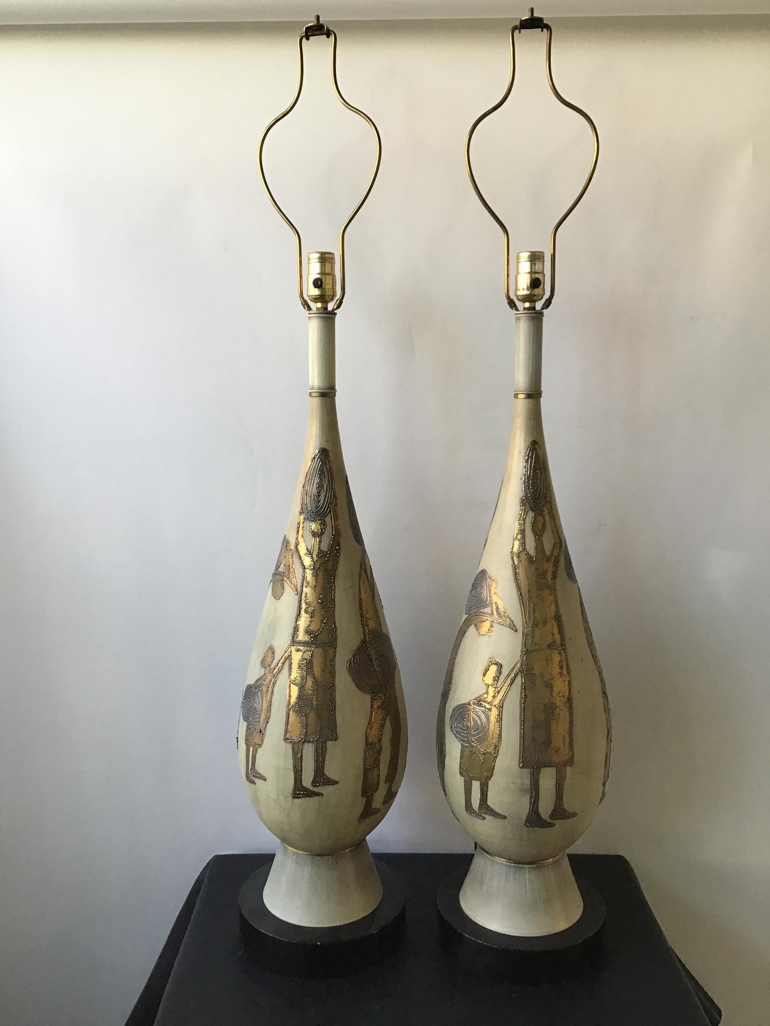 1950s large pair of ceramic lamps on wood bases. Scene of villagers.
Ceramic, hand painted using a gilt finish and raised paint.