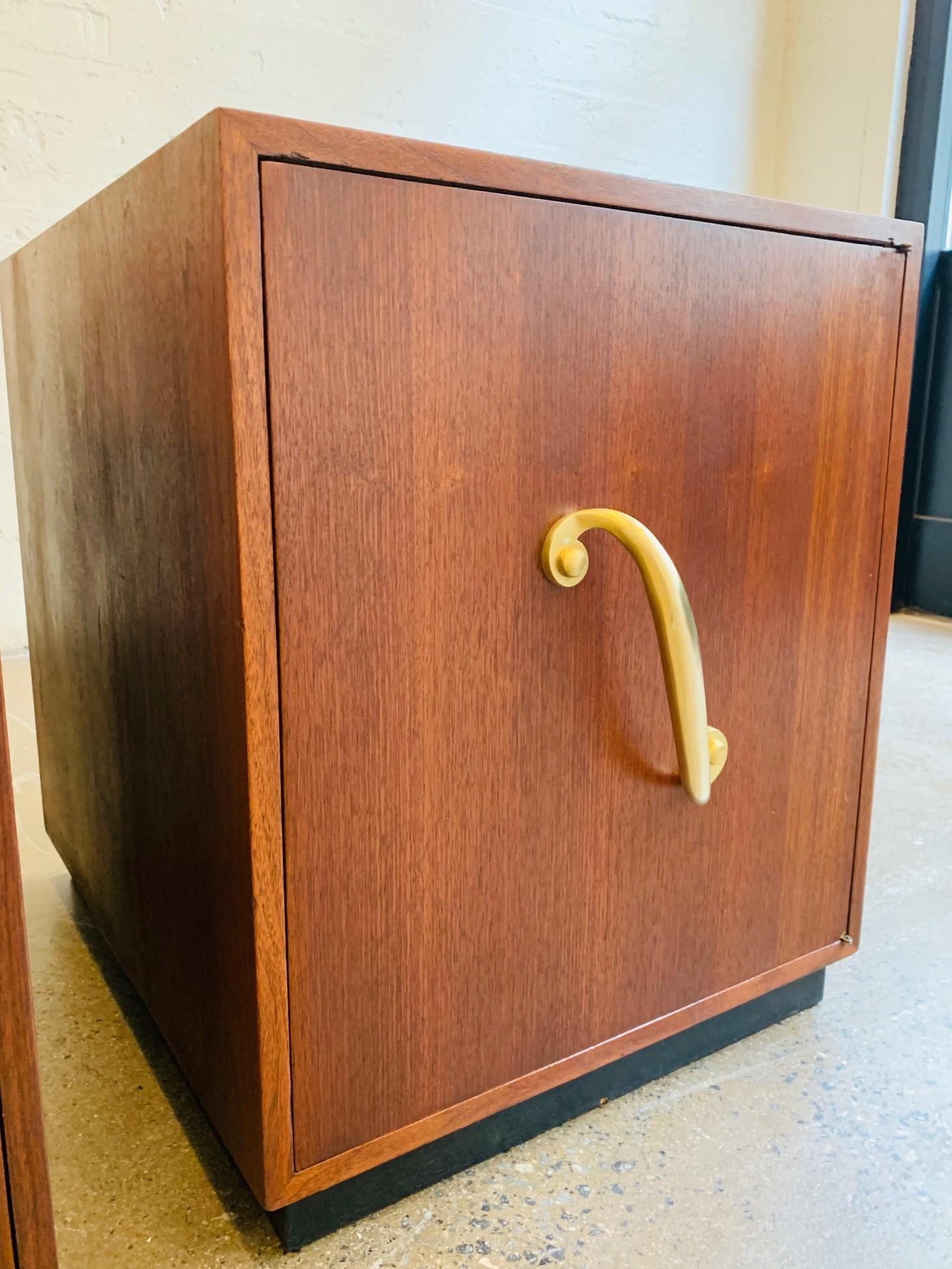 Pair of 1950s mahogany and bronze cabinets or nightstands. Has a solid, heavy bronze handle, a smoked glass top with an ebonized base. Has an adjustable shelf. Hollywood Regency style.