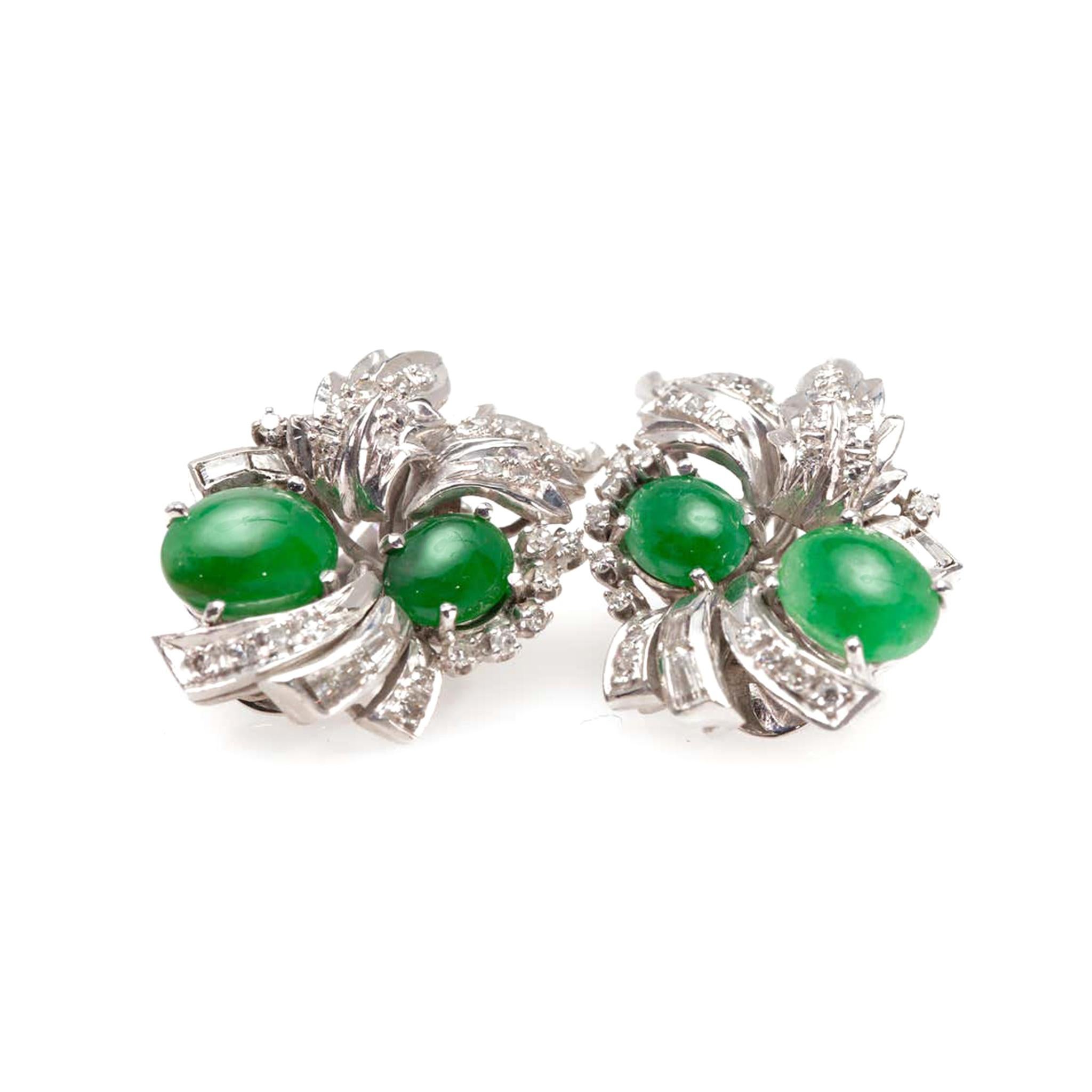 A pair of American natural apple green Jadeite jade and Diamond clip-on earrings from the 1940s - 1950s in 18K white gold. Featuring a delicate foliage design, each of this pair of clip-on earrings presents two natural apple green jadeite jade of