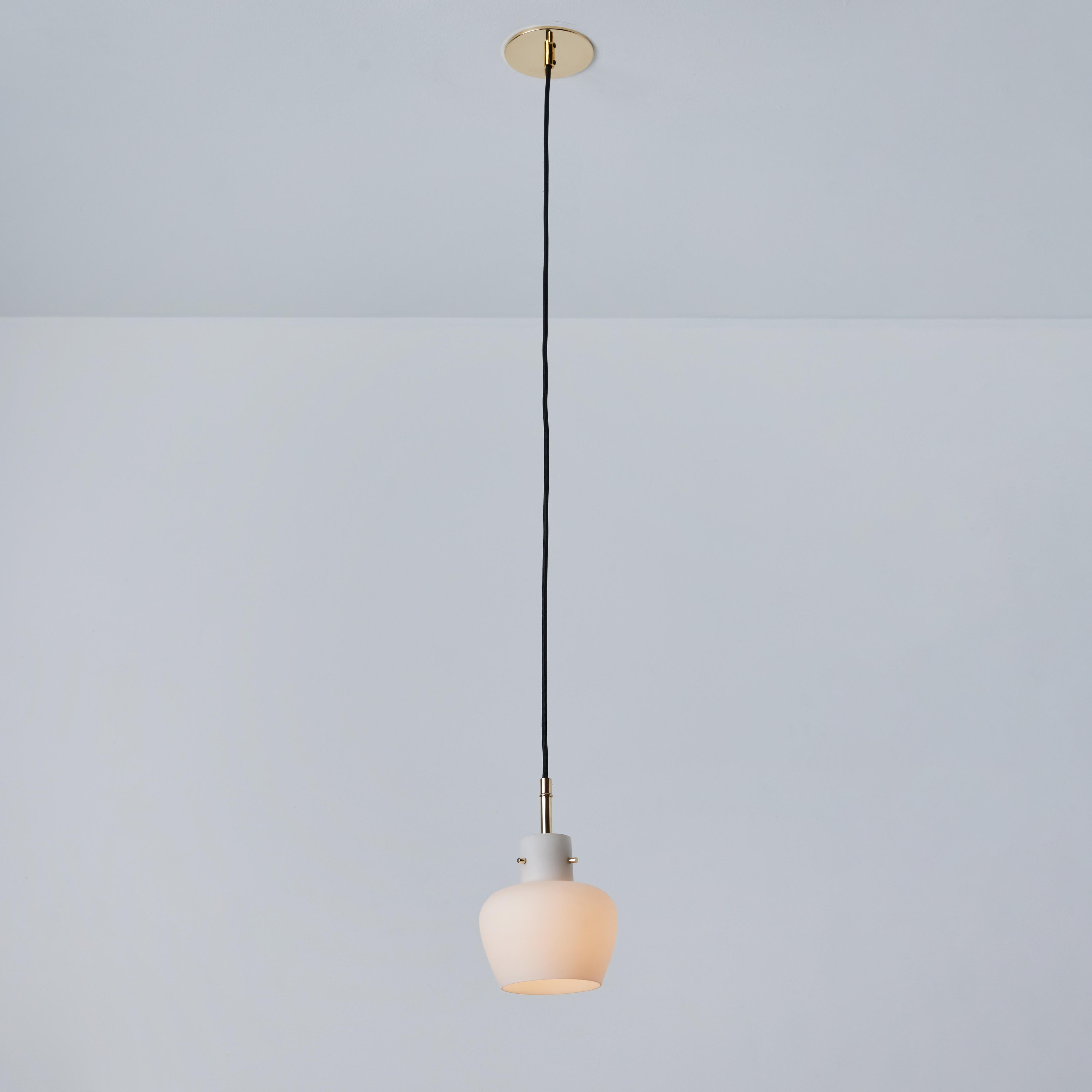 Pair of 1950s Opaline Glass Pendants in the Manner of Vilhelm Lauritzen. Executed in opaline matte glass and polished brass. A lyrical and elegant Danish modern design with a sculptural form characteristic of Lauritzen's finest work of the