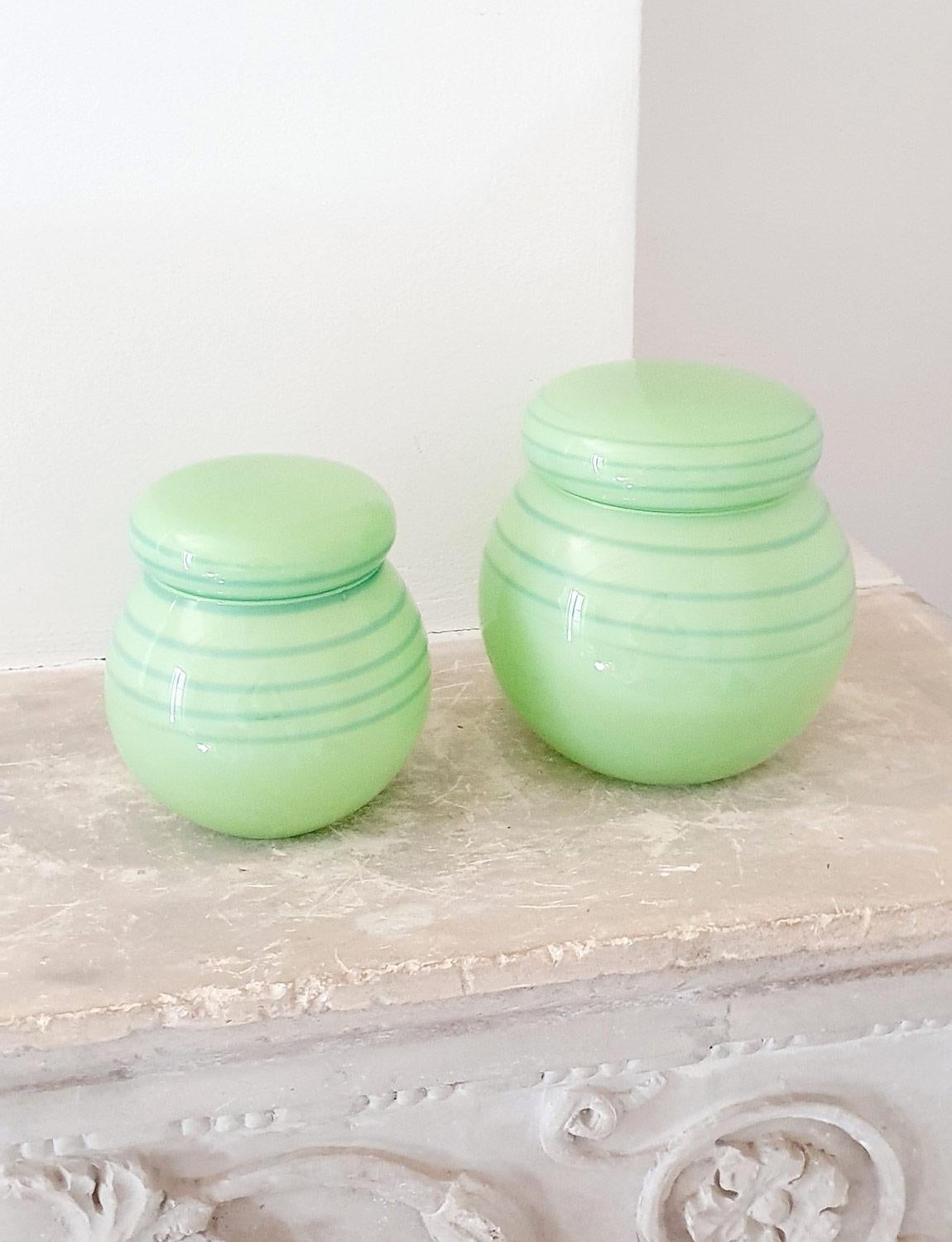 Made in the 1950s in opaque green glass, these Italian round shaped hand-blown pots both with their own lids, have a pale blue spiral pattern that encircles their lid and the upper part of their base. I found these wonderful pieces in Florence, they