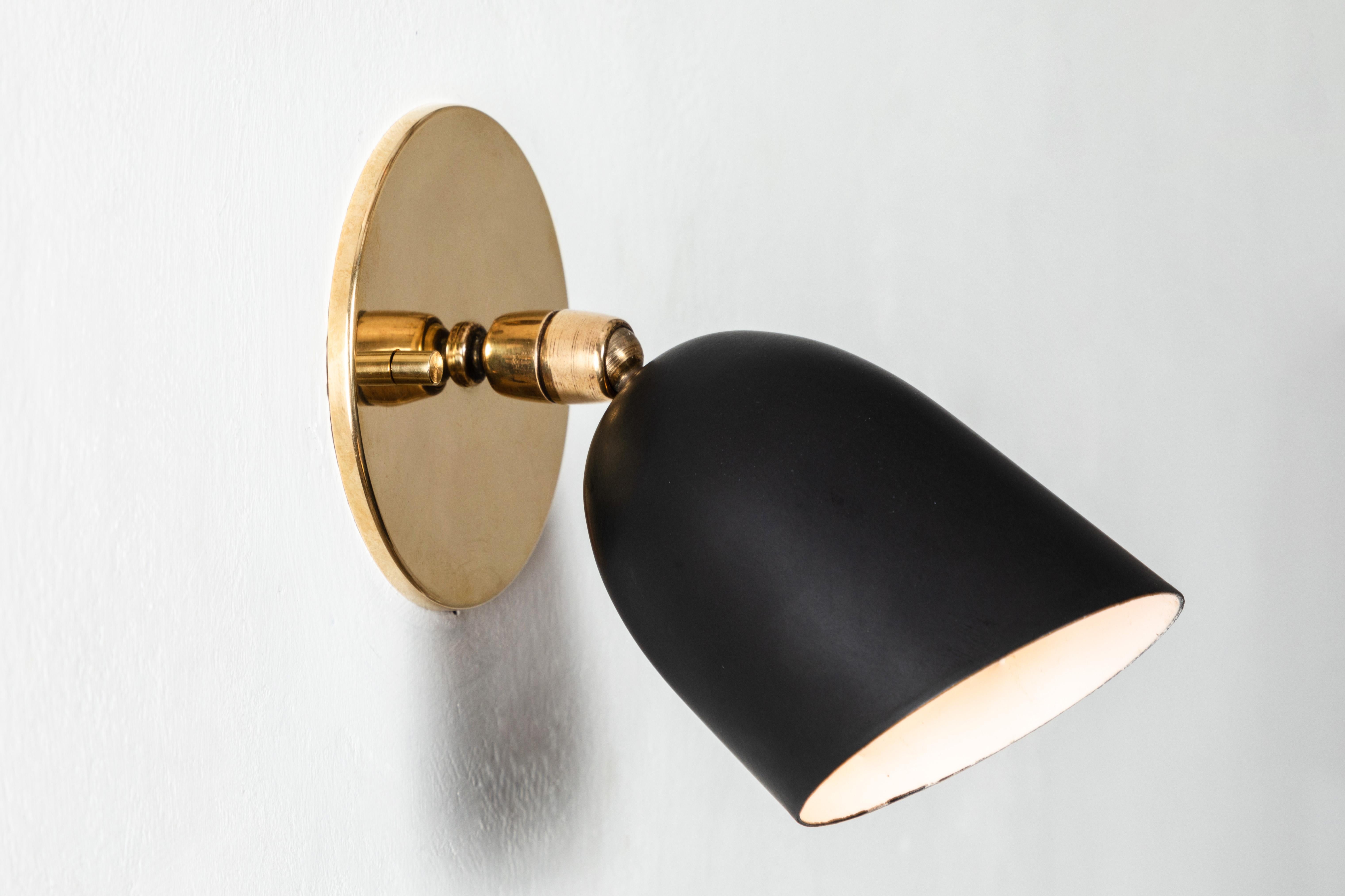 Pair of 1950s petite black sconces by Gino Sarfatti for Arteluce. Executed in black painted aluminum and brass. Double ball jointed arm allows flexible shade adjustments and multiple configurations. The simplicity of Sarfatti's design and the