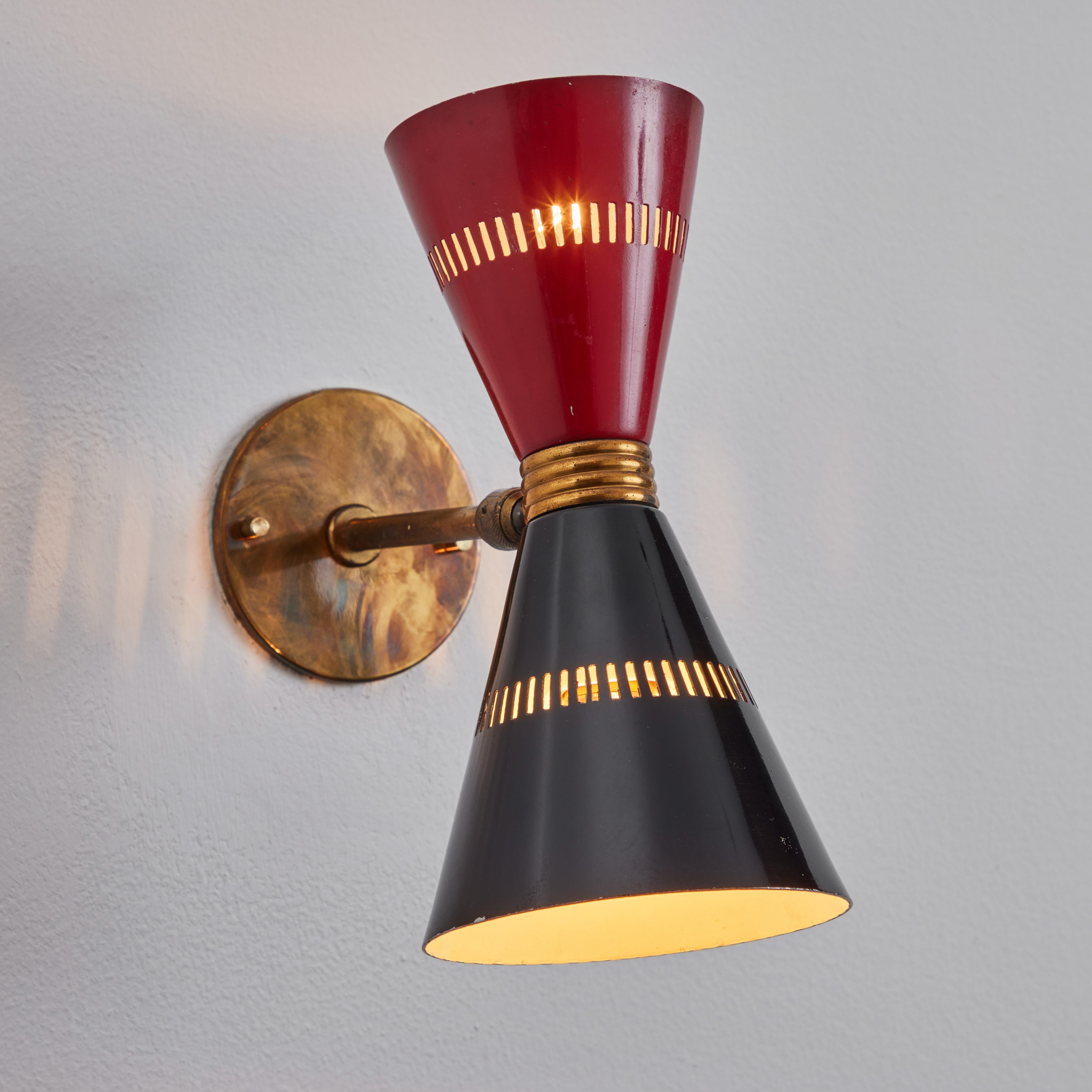 Pair of 1950s red & black Stilnovo Diabolo sconces. Executed in in perforated black and red painted metal and patinated brass. Lamp adjusts freely on a flexible ball joint to a variety of angles. A sculptural and refined design characteristic of